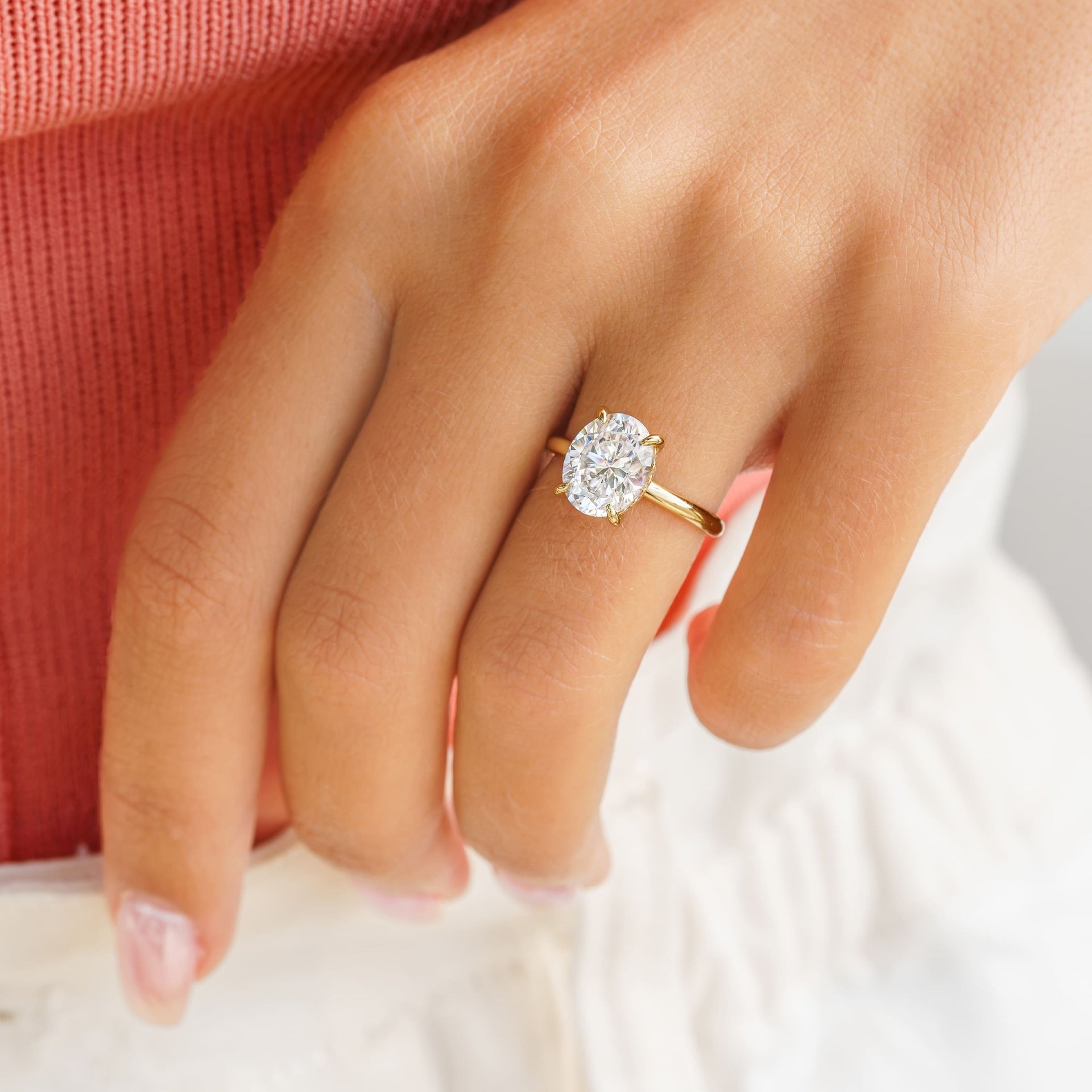 woman wearing oval shaped gold engagement ring