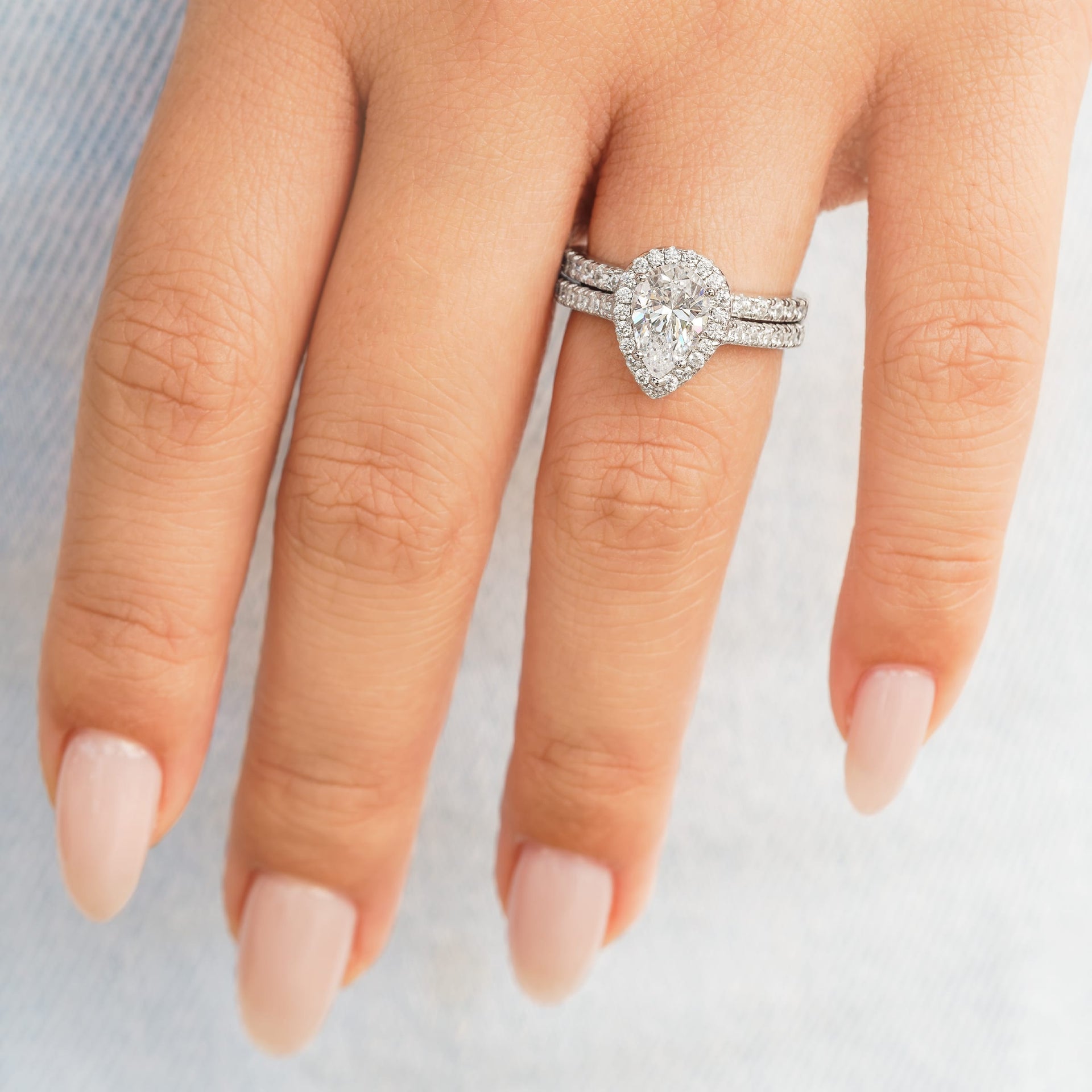 woman wearing silver pear shaped engagement ring on hand