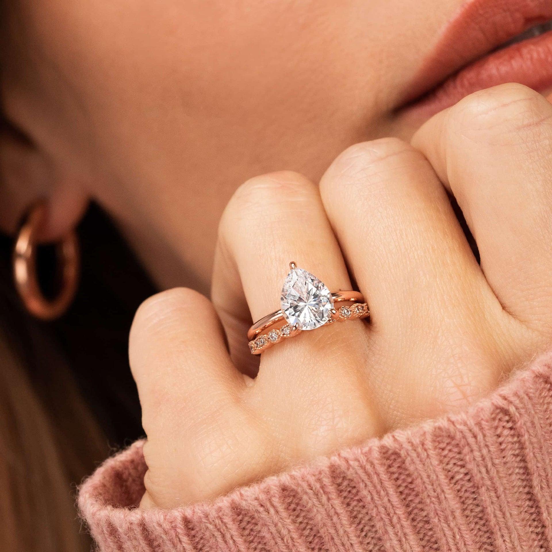 woman wearing pear shaped engagement ring with vintage wedding band