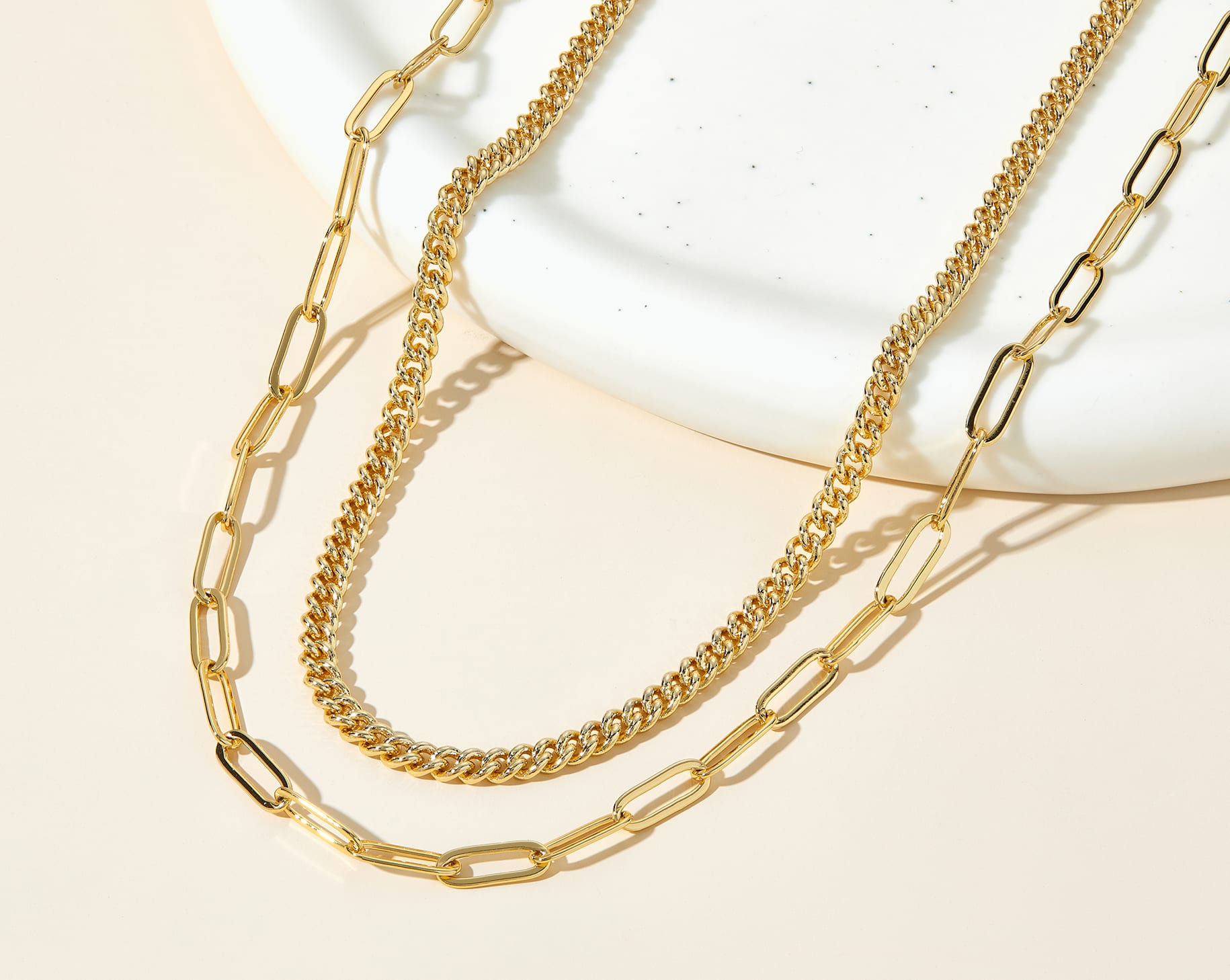 gold necklace stack on neutral background