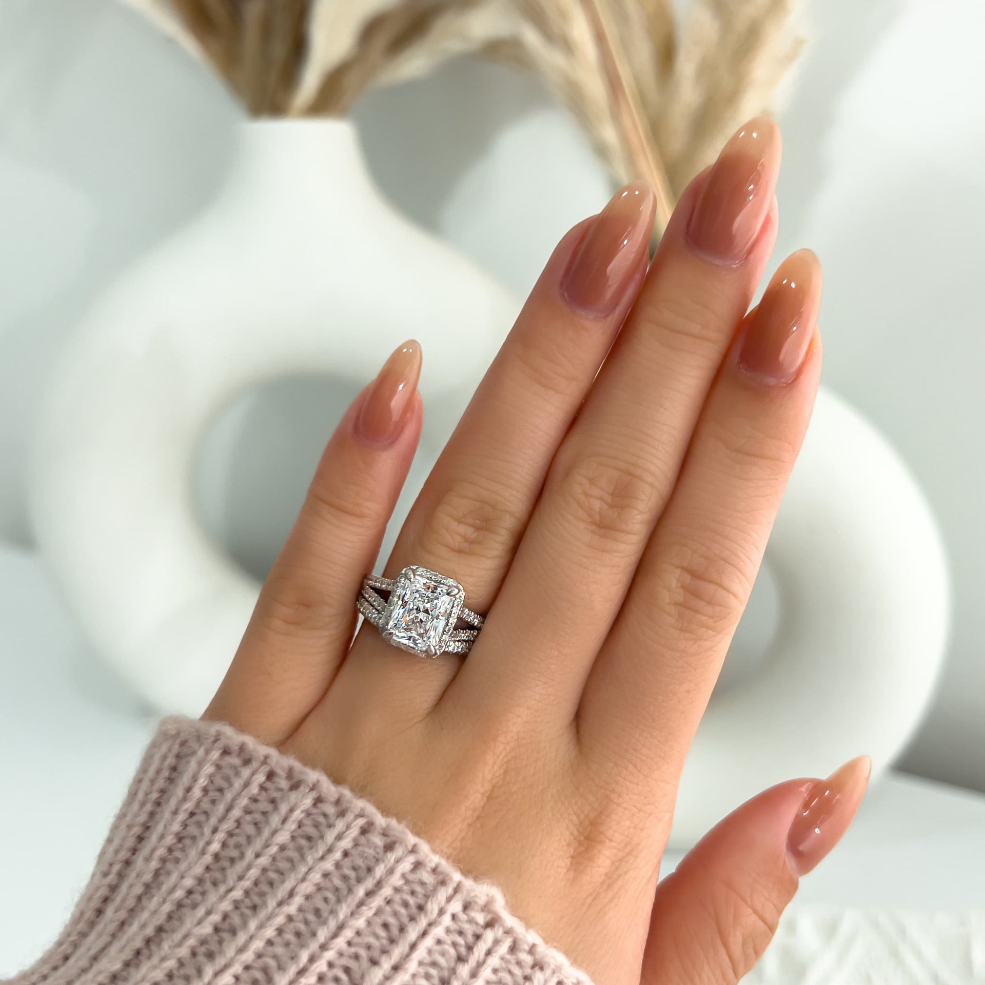 elegant silver split shank wedding ring set on model with nude nails and pink sweater