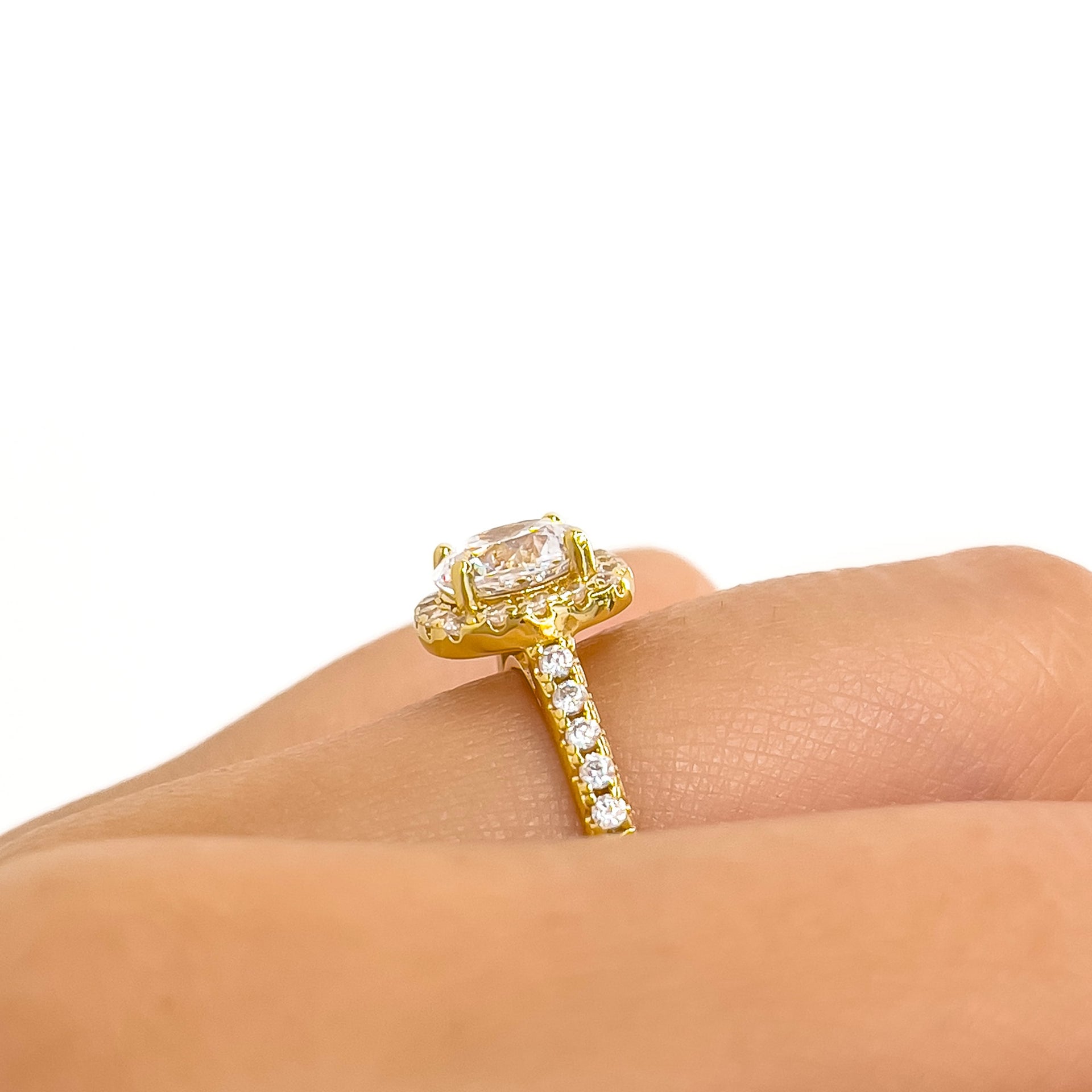 setting shot of gold cushion halo round cut engagement ring