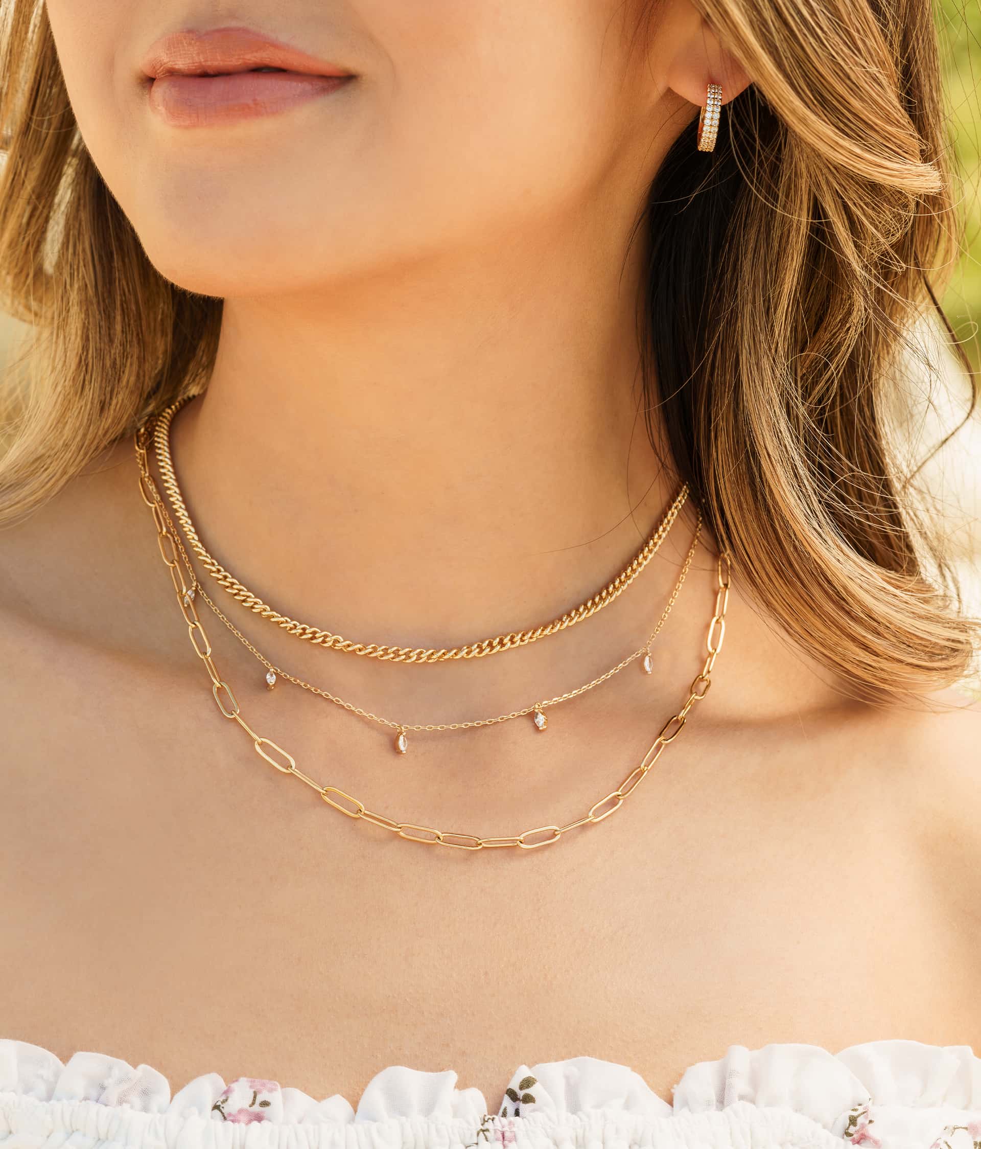 woman wearing three layer necklace stack in gold