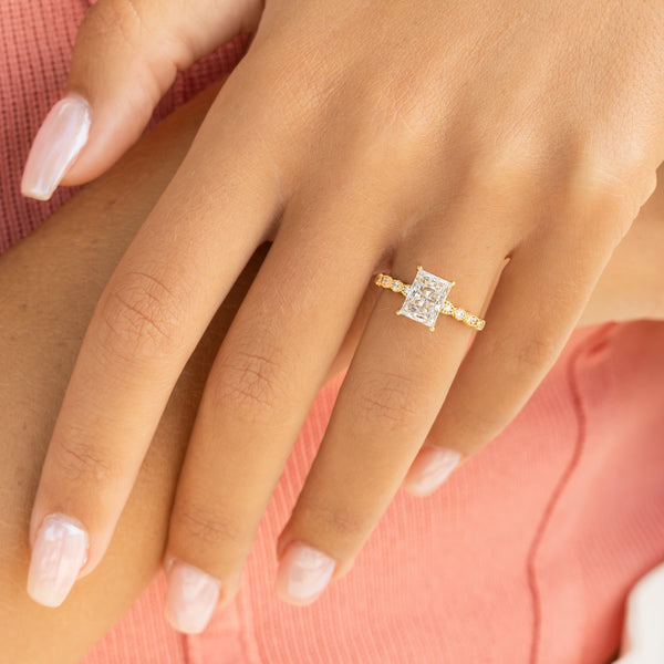 woman wearing radiant cut vintage engagement ring with pink top