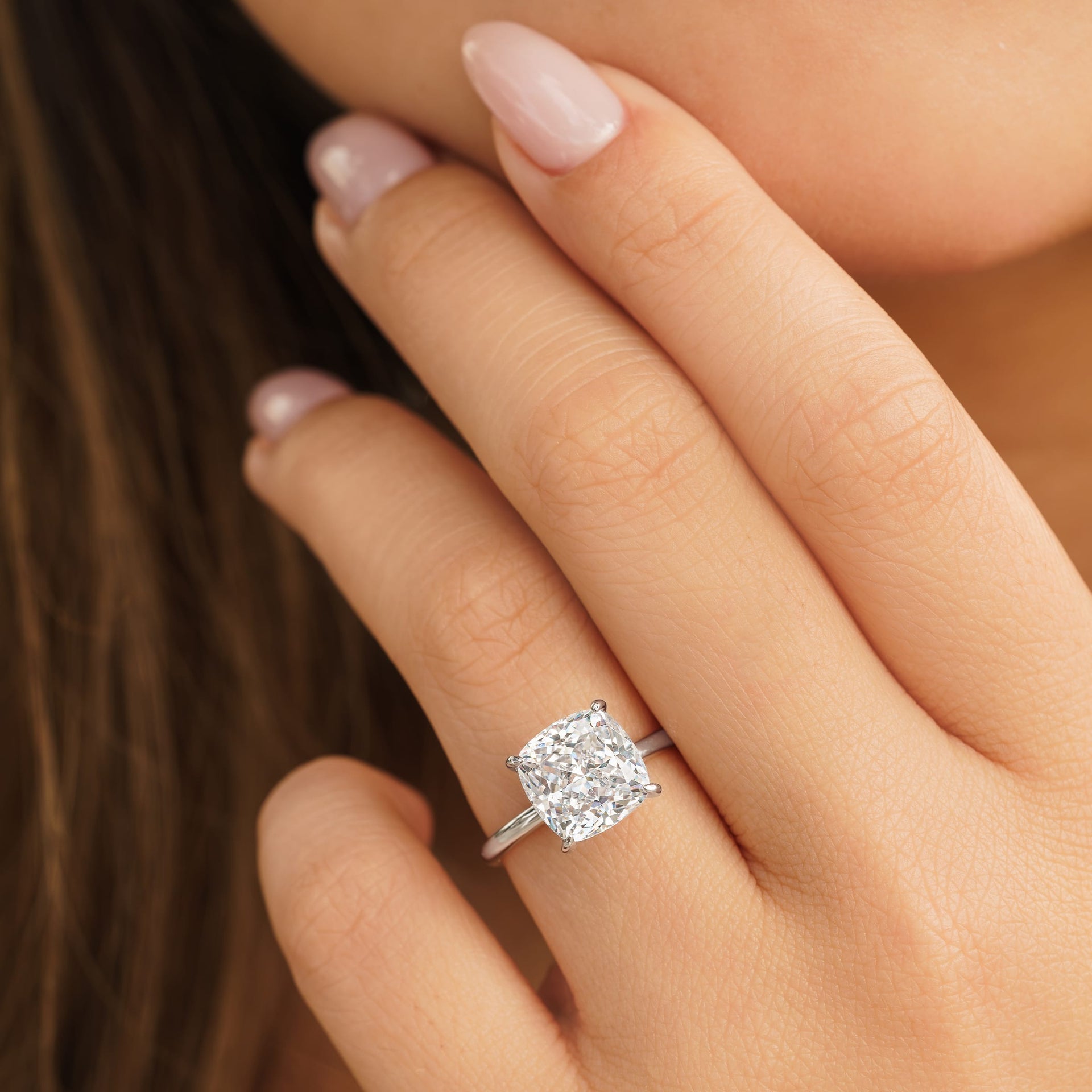 woman wearing silver cushion cut engagement ring on hand