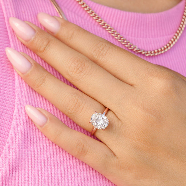 woman wearing rose gold oval shaped engagement ring