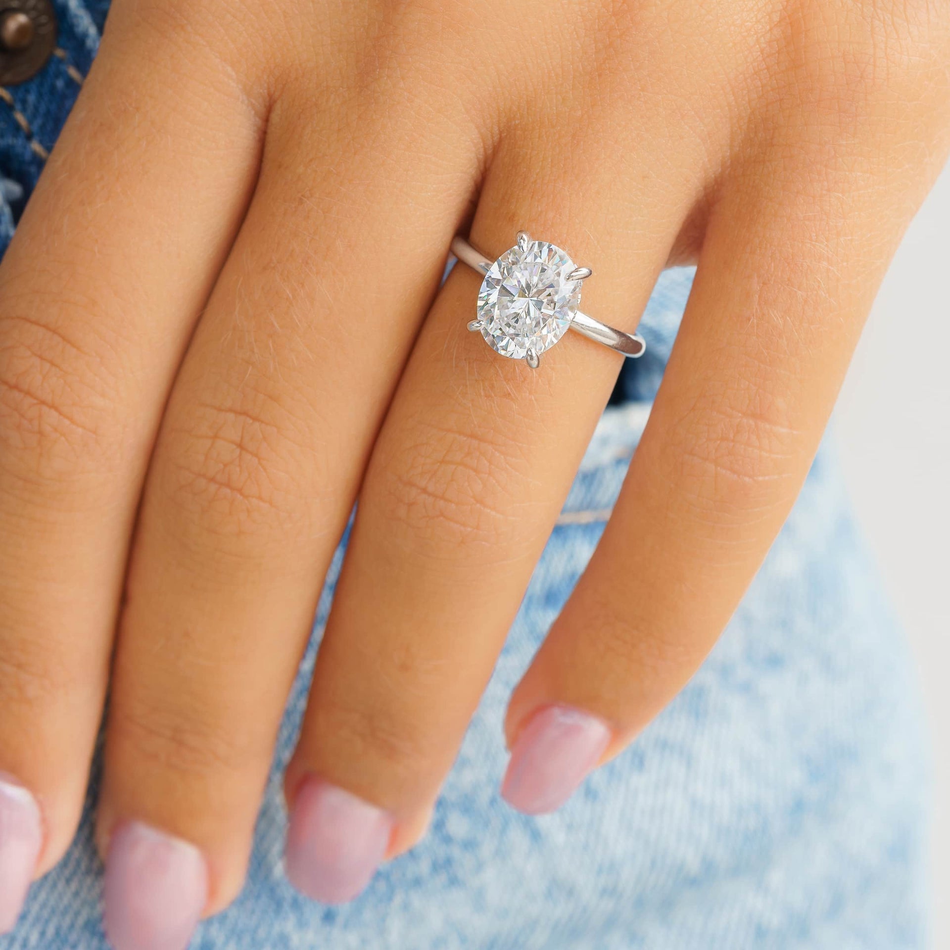 woman wearing silver oval shaped engagement ring