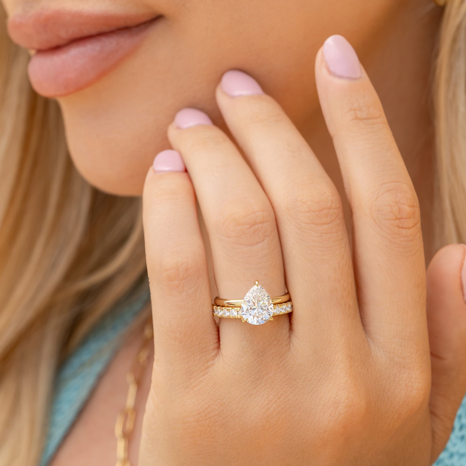 woman wearing pear shaped engagement ring with eternity wedding band