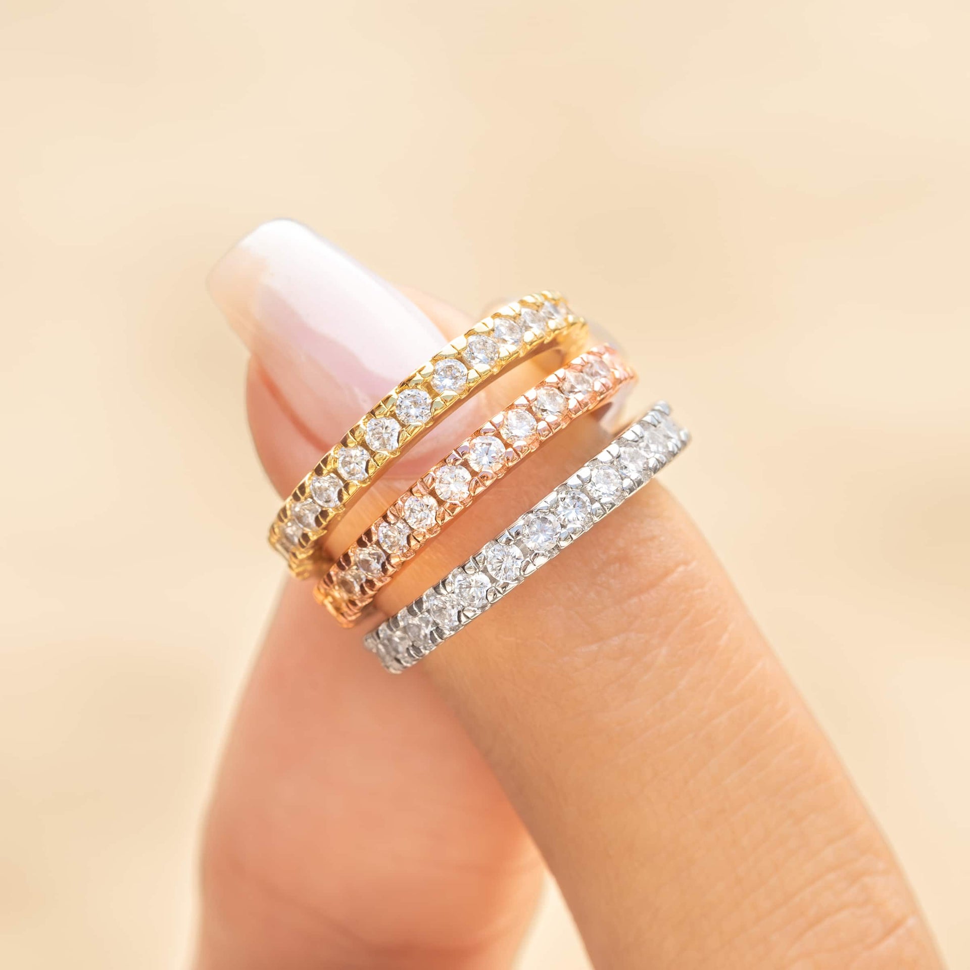 woman pinching all three colors of eternity wedding band