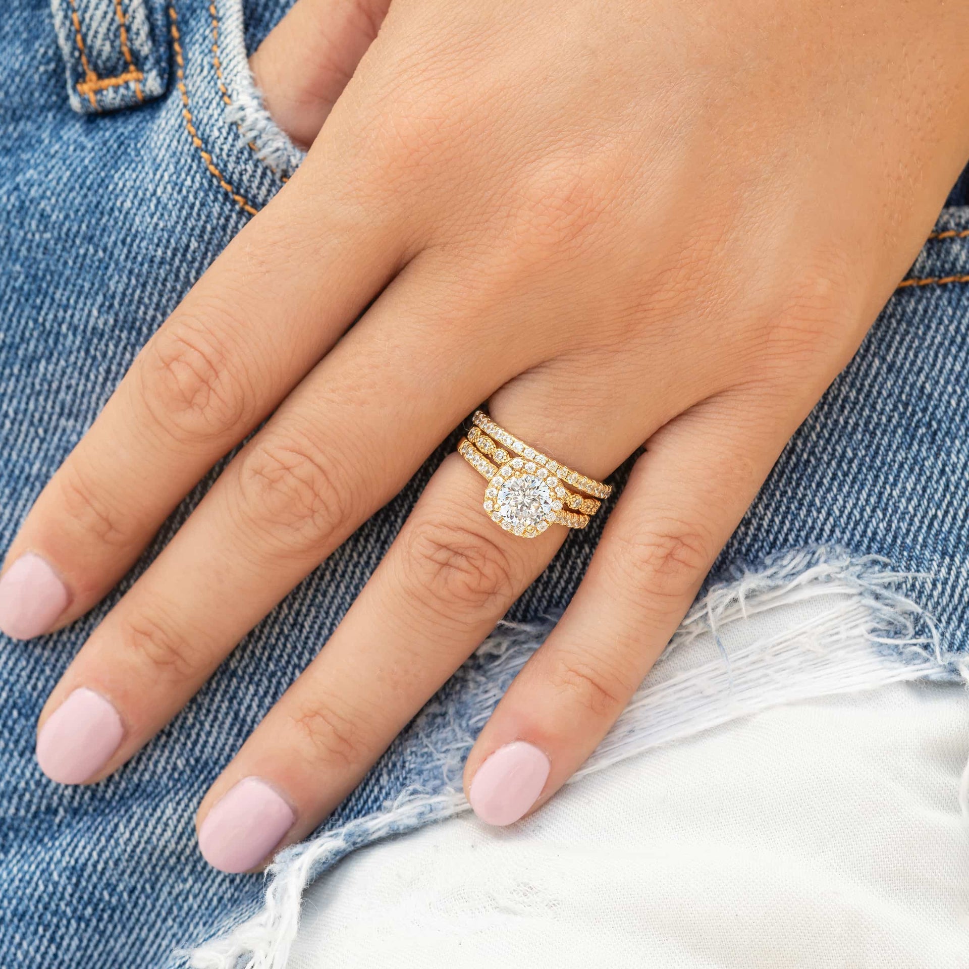 woman wearing triple stack with halo cushion cut wedding ring set
