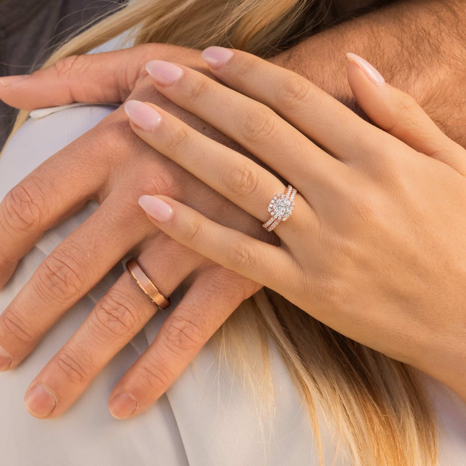 couple holding hands wearing cushion cut rose gold engagement ring