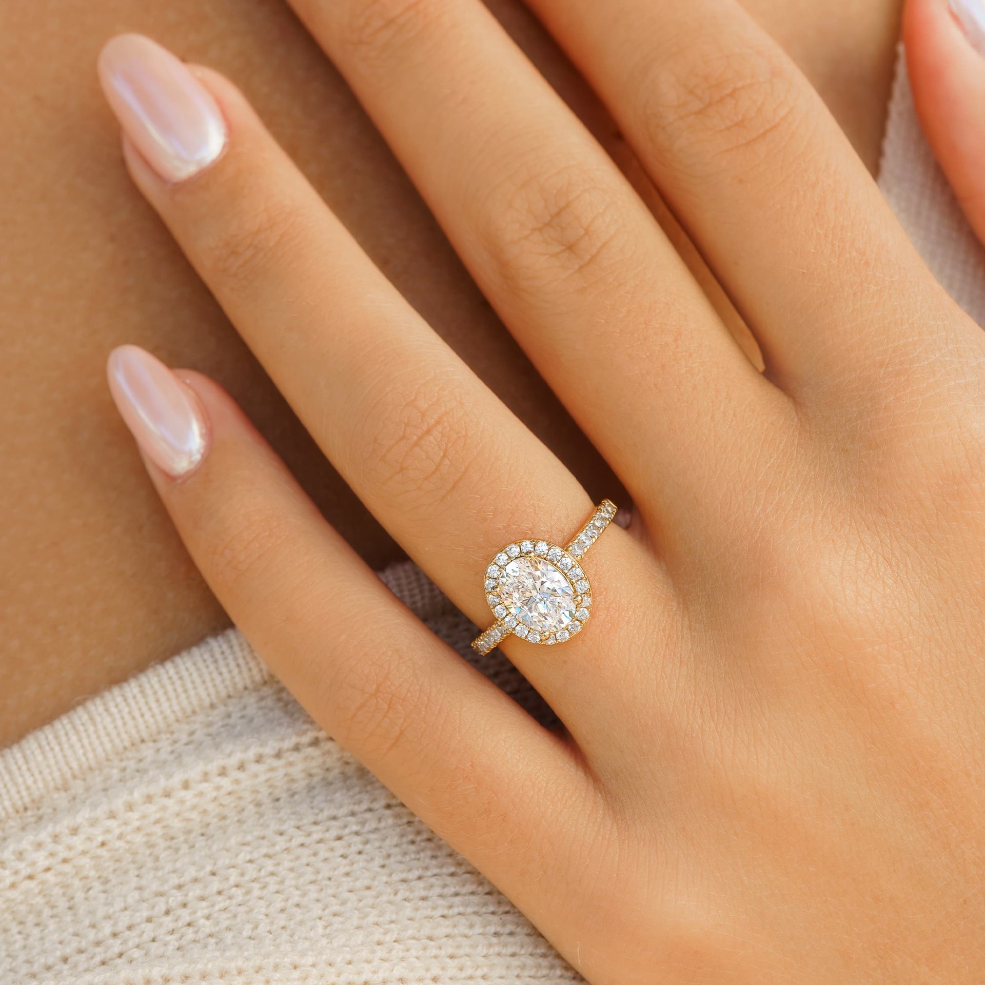 Oval cut gold engagement ring on a female hand