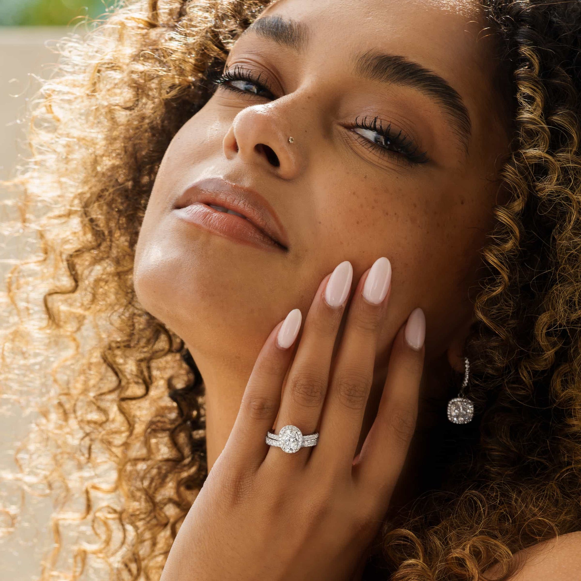 gorgeous model wearing silver halo engagement ring on hand