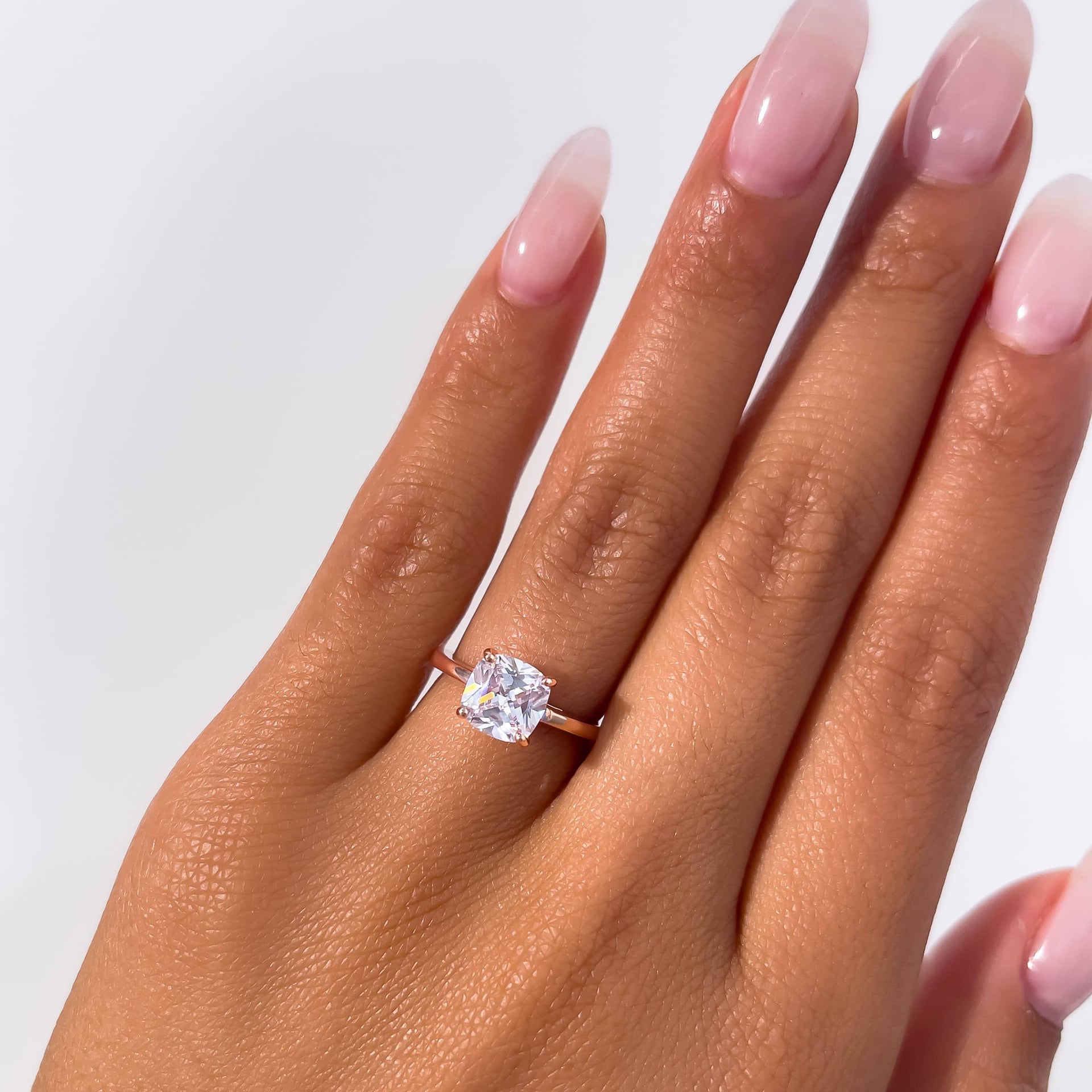 1 carat cushion cut solitaire engagement ring on model with neutral nails