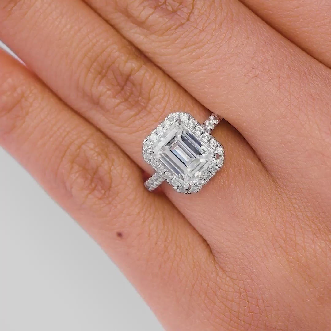 Multi-view video of stunning silver emerald cut engagement ring with a half eternity band, being shown by model with light pink nails