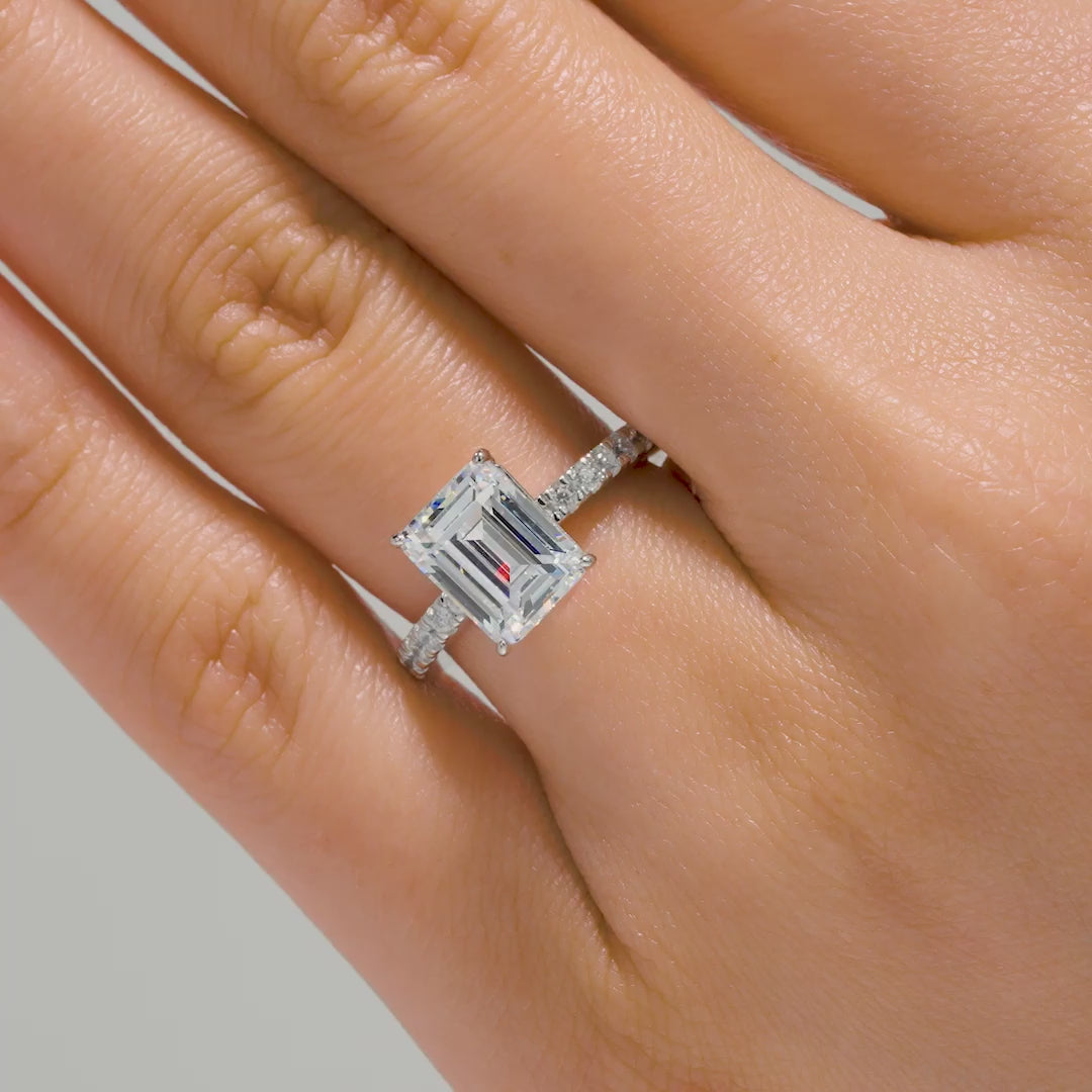 silver 3 emerald cut engagement ring modeled on female hand with pink nails