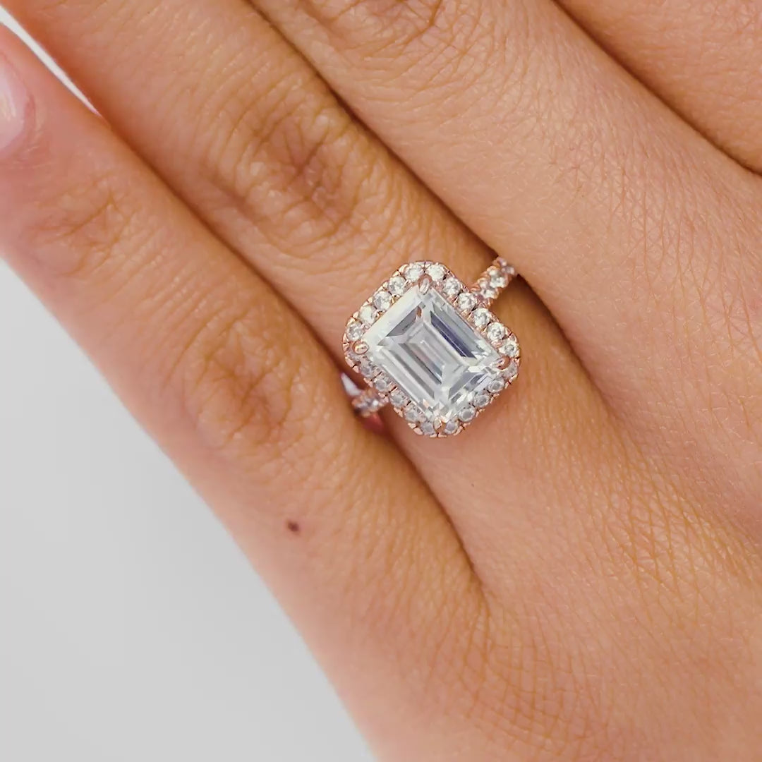 Multi-view video of stunning rose gold emerald cut engagement ring with a half eternity band, being shown by model with light pink nails