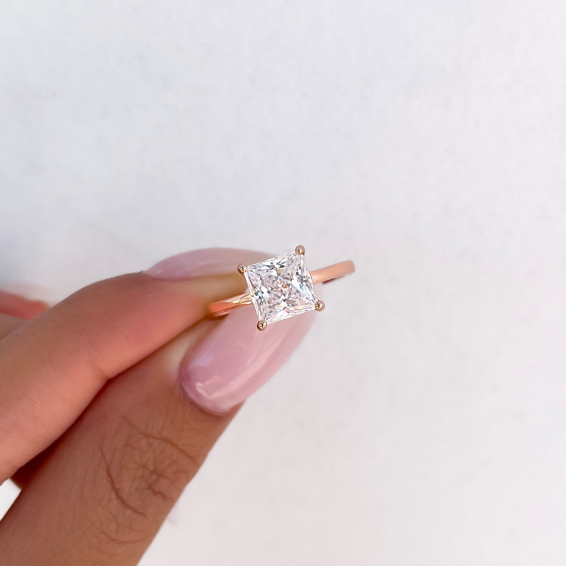 rose gold princess cut solitaire engagement ring in hand