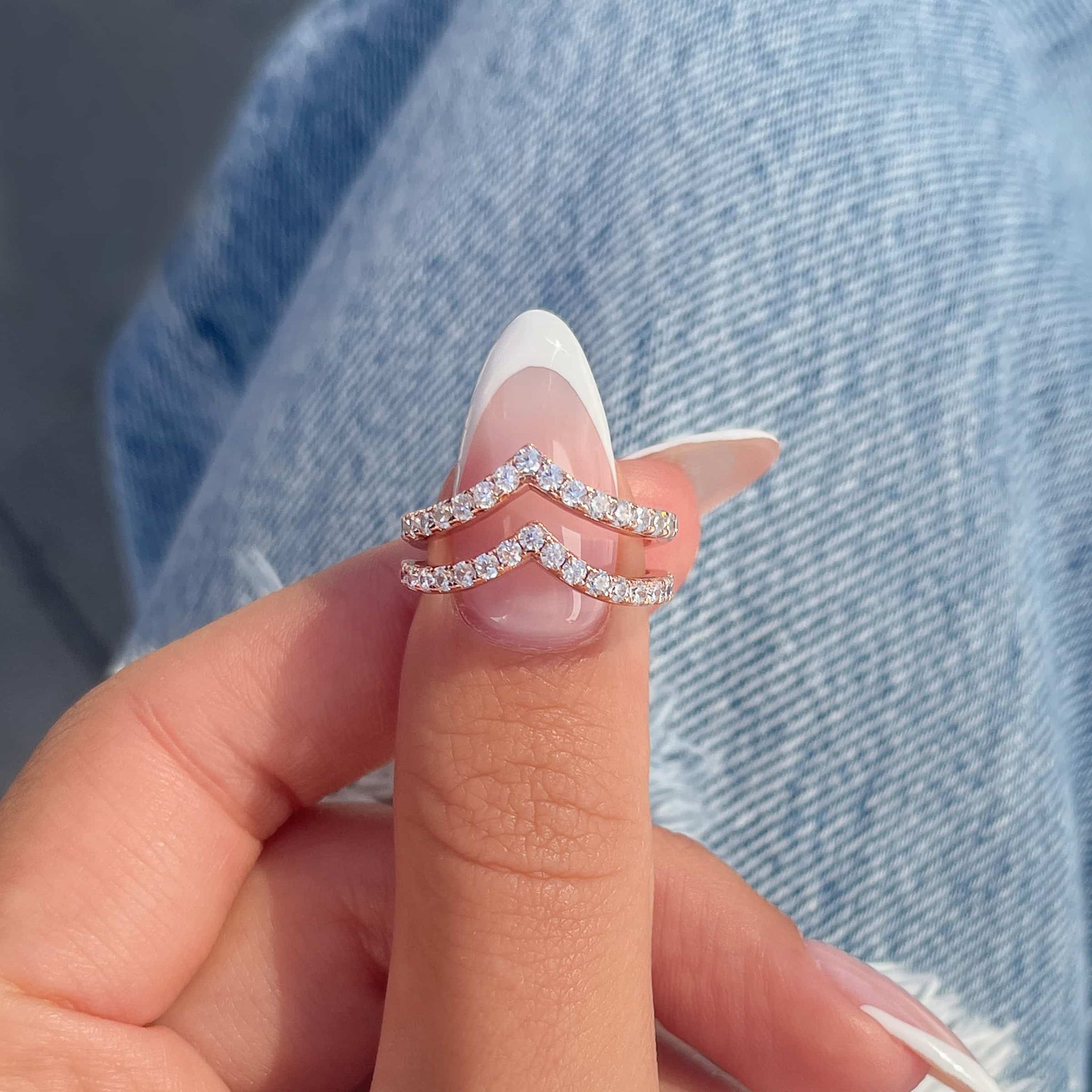Half eternity chevron band set in the rose gold variant on thumb with French tip nail