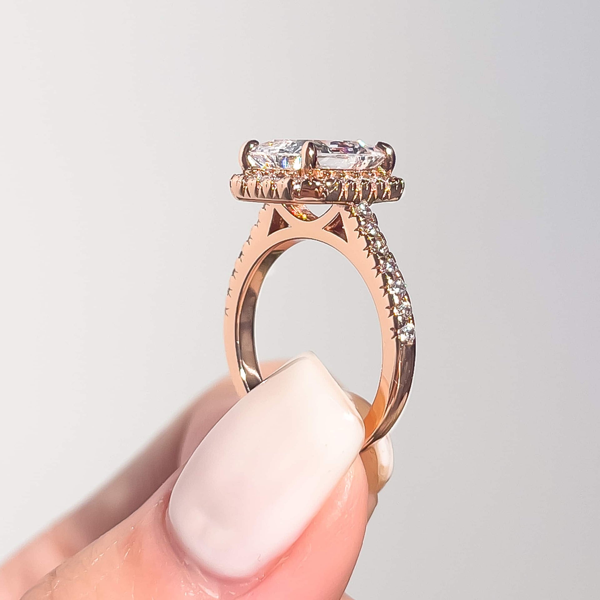 side view of rose gold radiant halo engagement ring and half eternity band detail