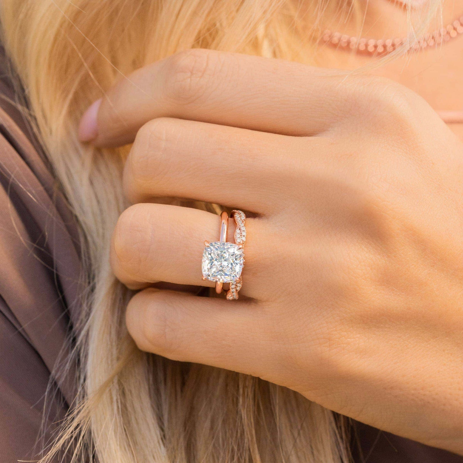 woman wearing rose gold cushion cut engagement ring with wedding band