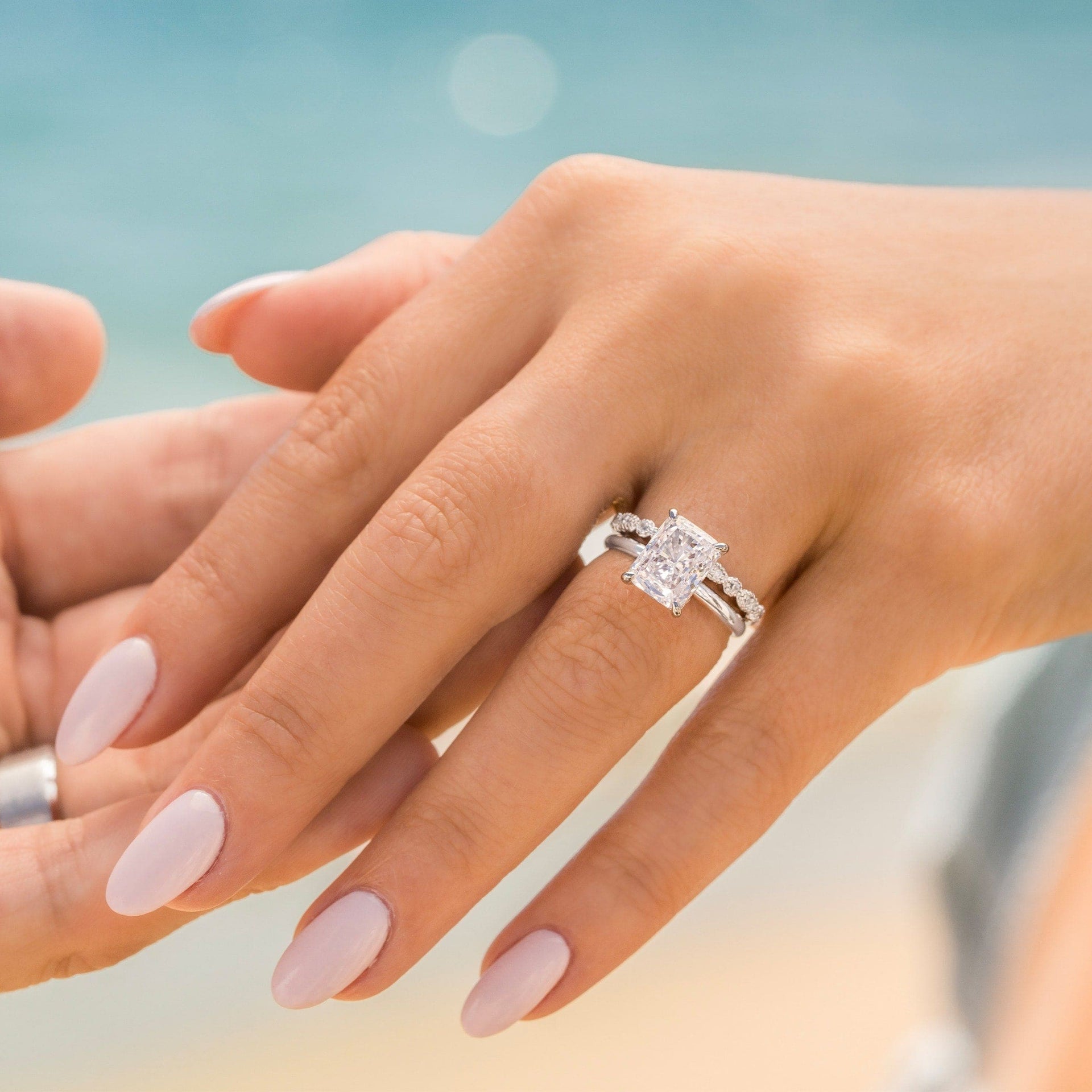 woman wearing silver radiant cut engagement ring