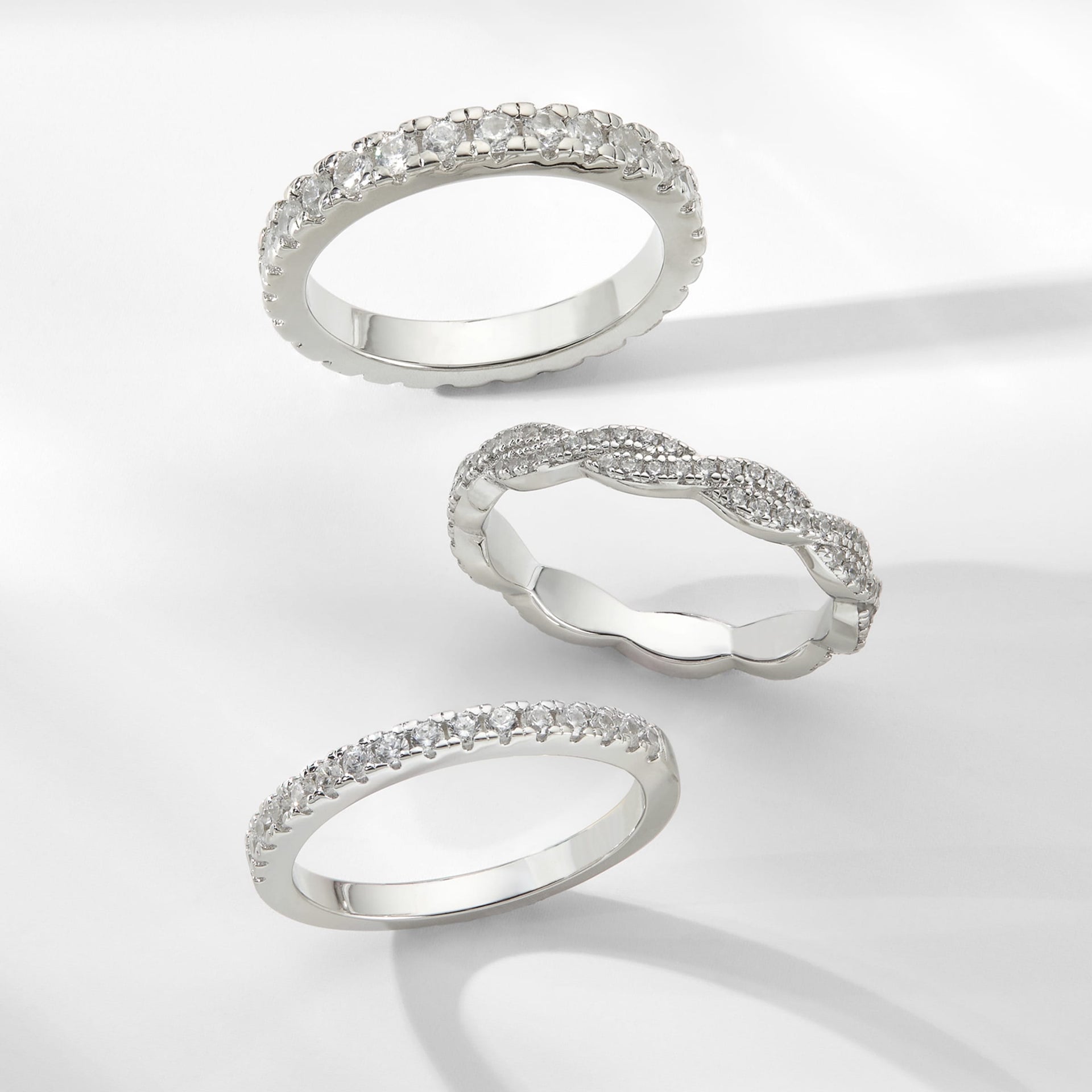three affordable wedding bands on neutral gray background