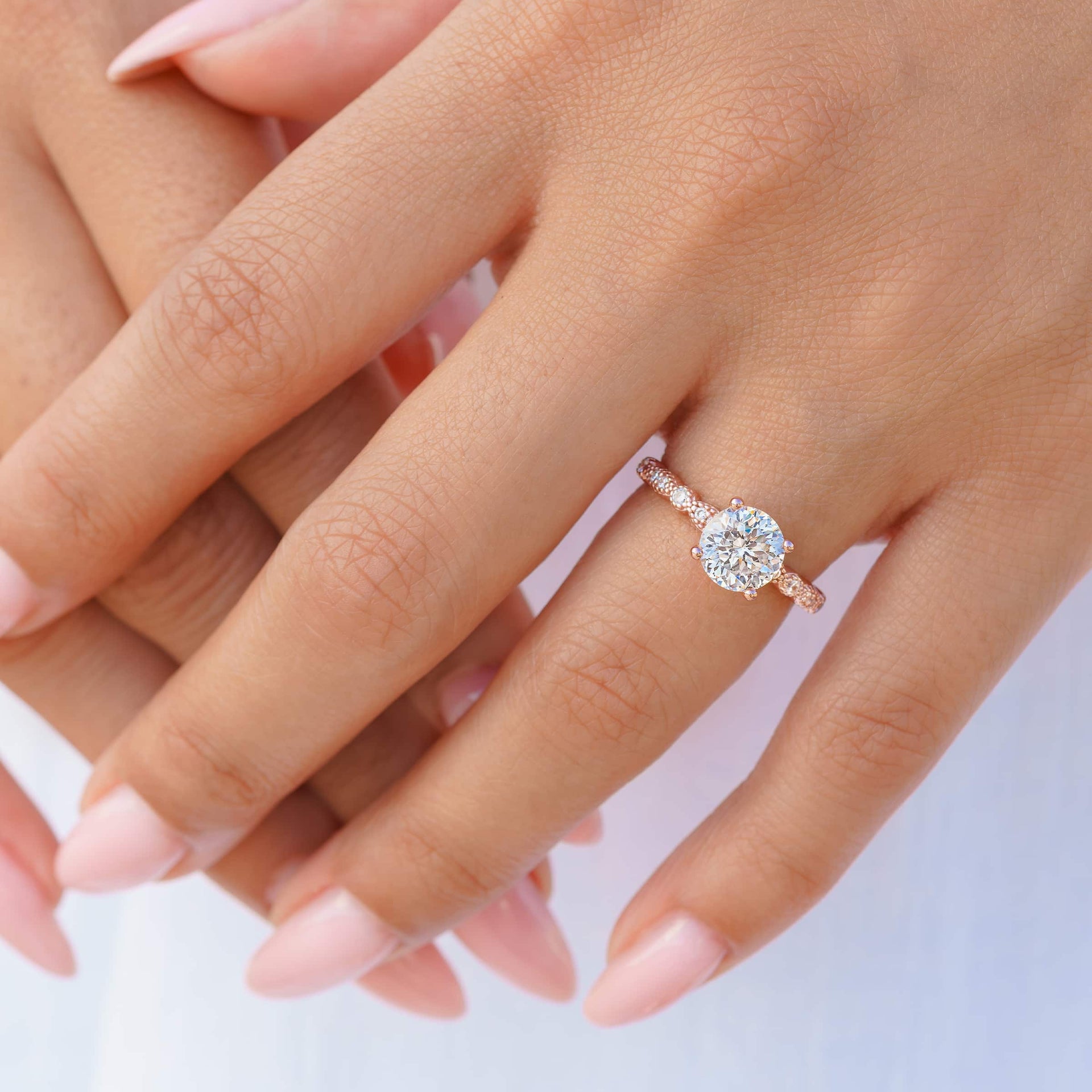 stunning rose gold 1.5 ct sofia engagement ring on models hand with pink nails