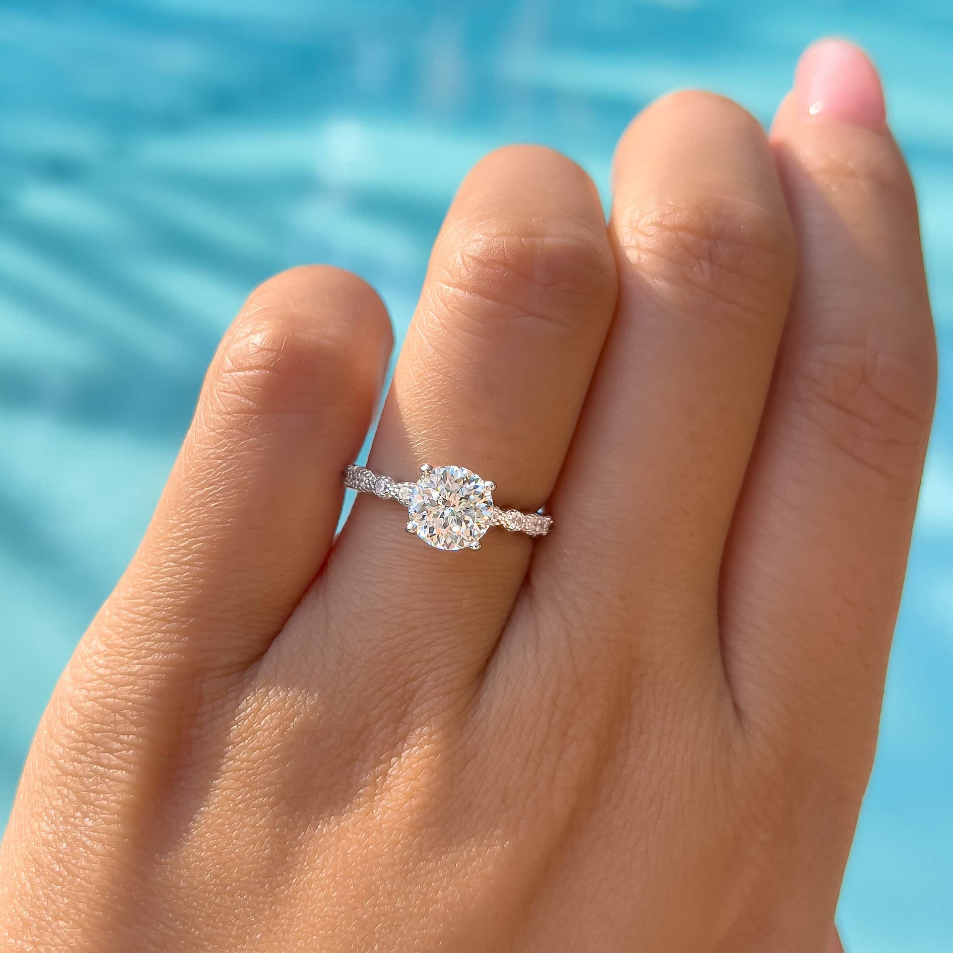 stunning round cut vintage engagement ring on ladies hand by pool