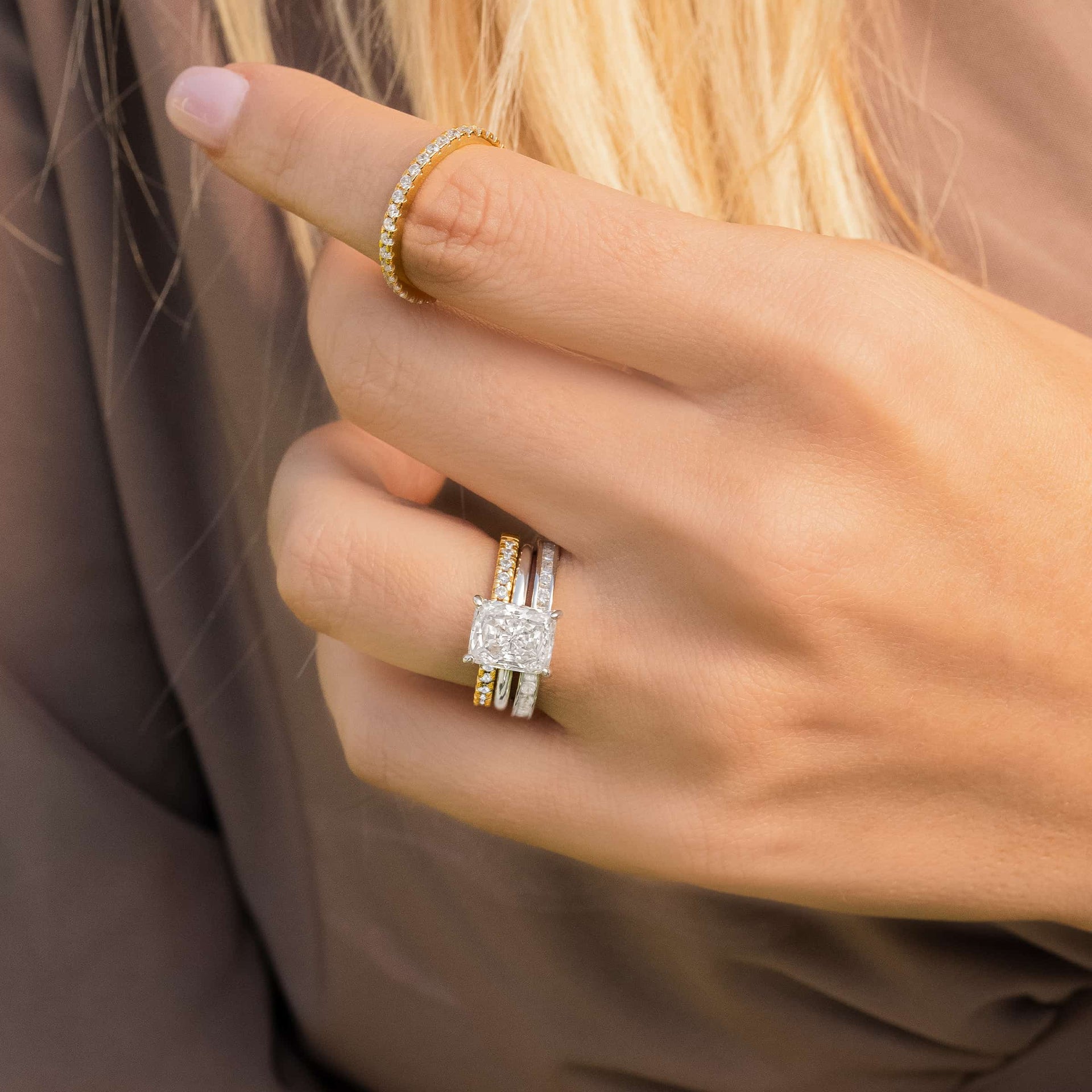 woman wearing silver engagement ring with gold and silver wedding bands