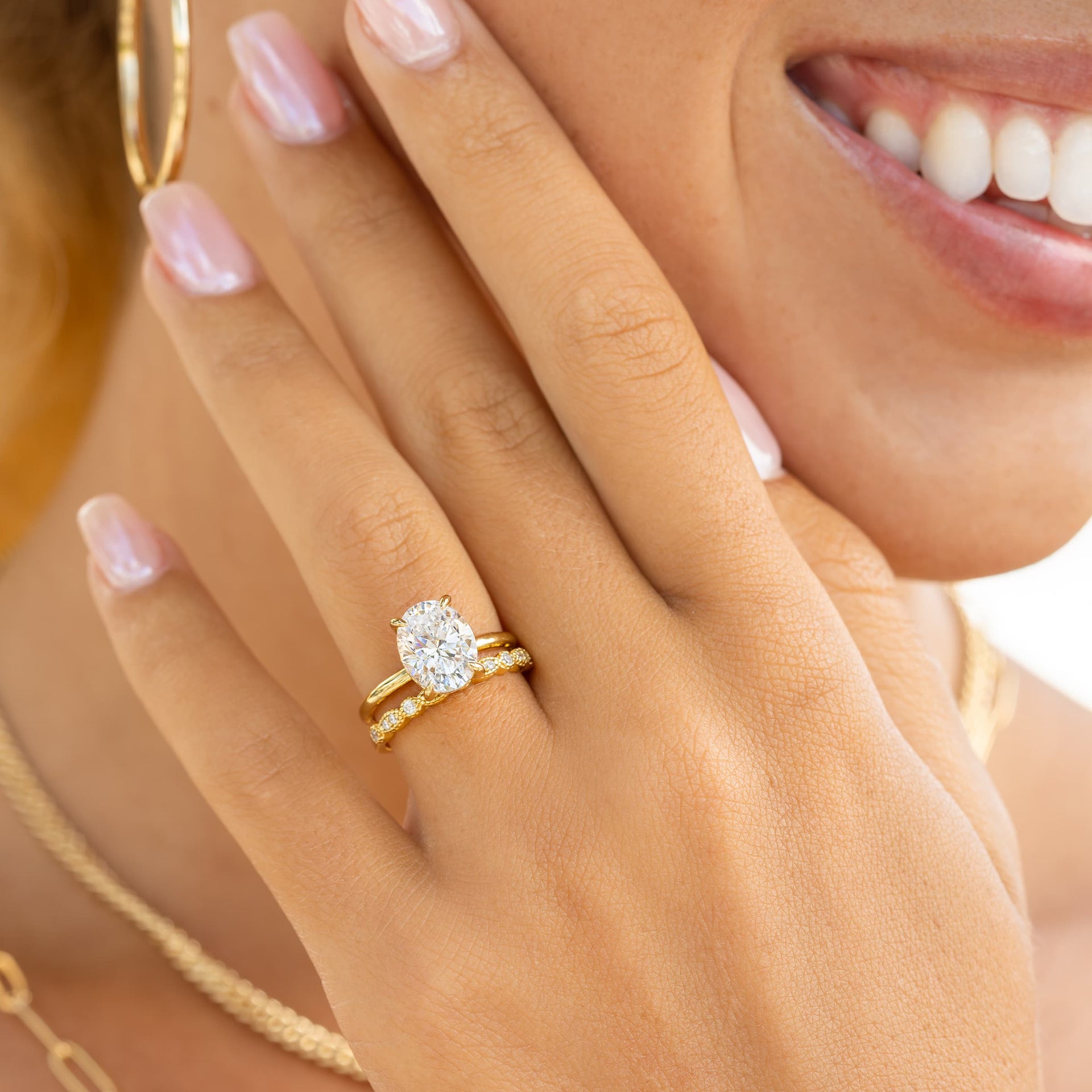 woman wearing gold vintage wedding band paired with oval shaped engagement ring