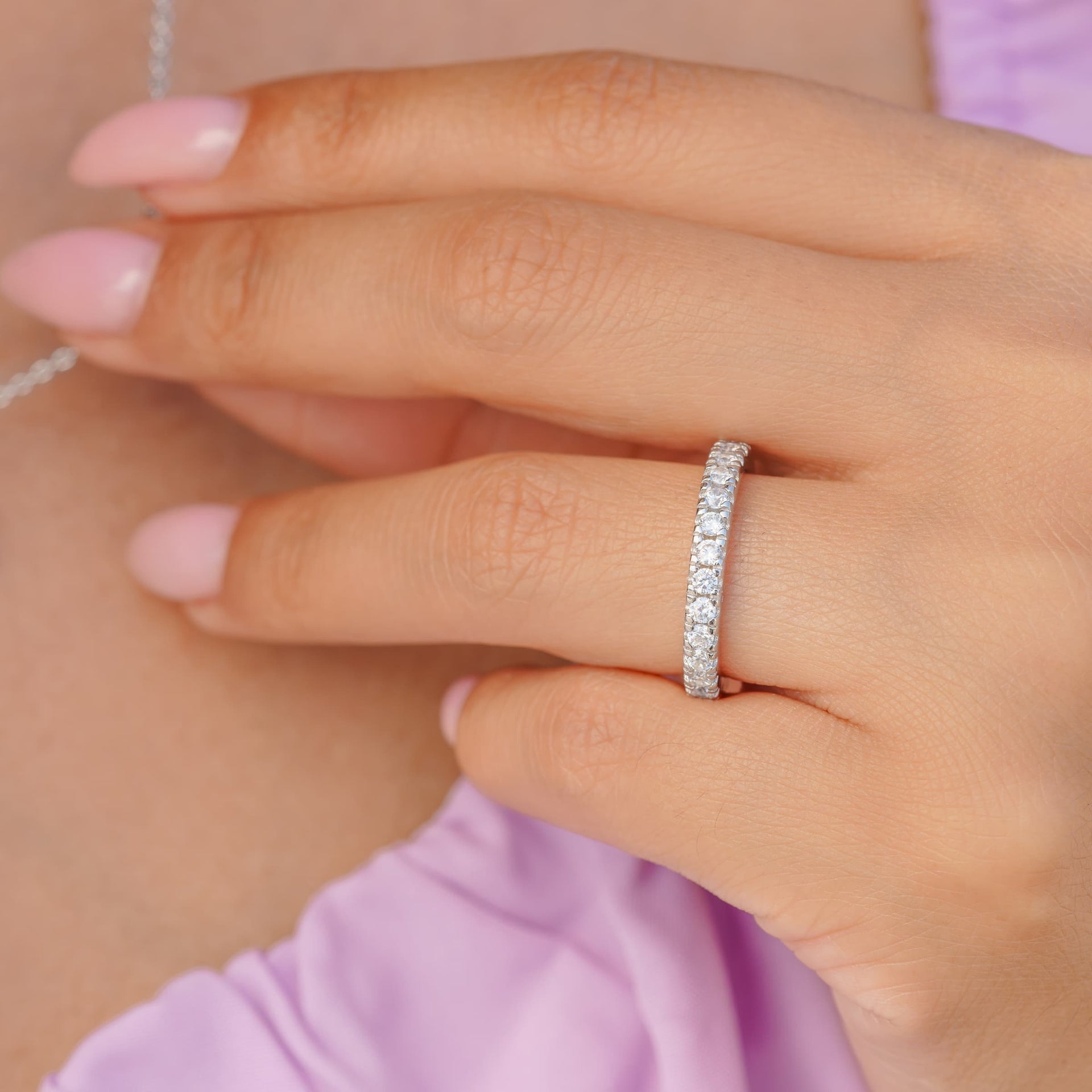 woman wearing silver eternity wedding band on finger