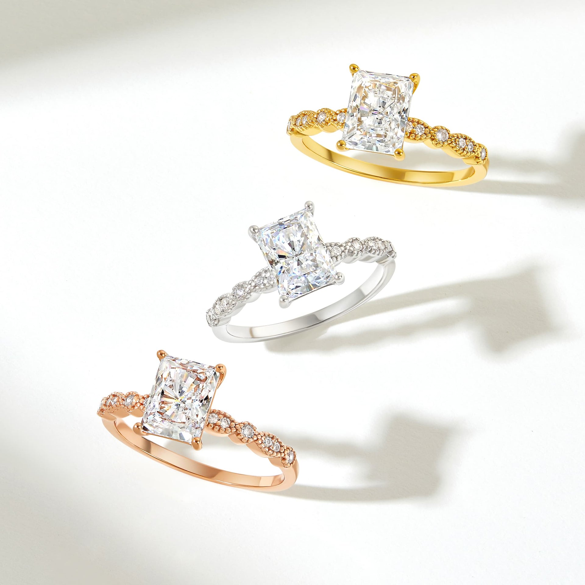 stunning radiant cut engagement rings shown in rose gold, silver, gold with vintage band detailing