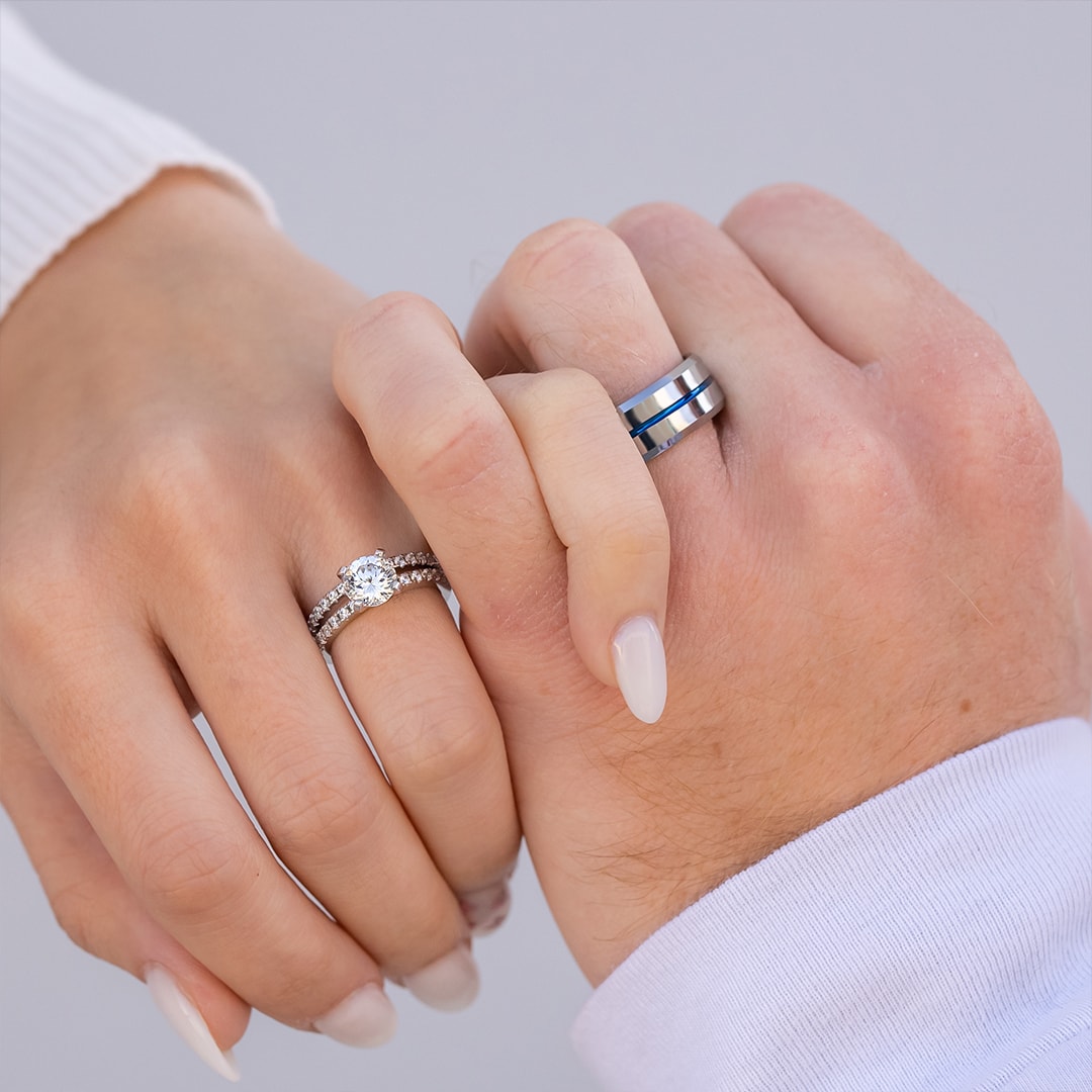 couple holding hands wearing wedding rings