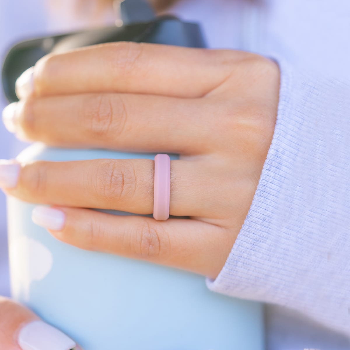 Female hand wearing a pink silicone wedding ring