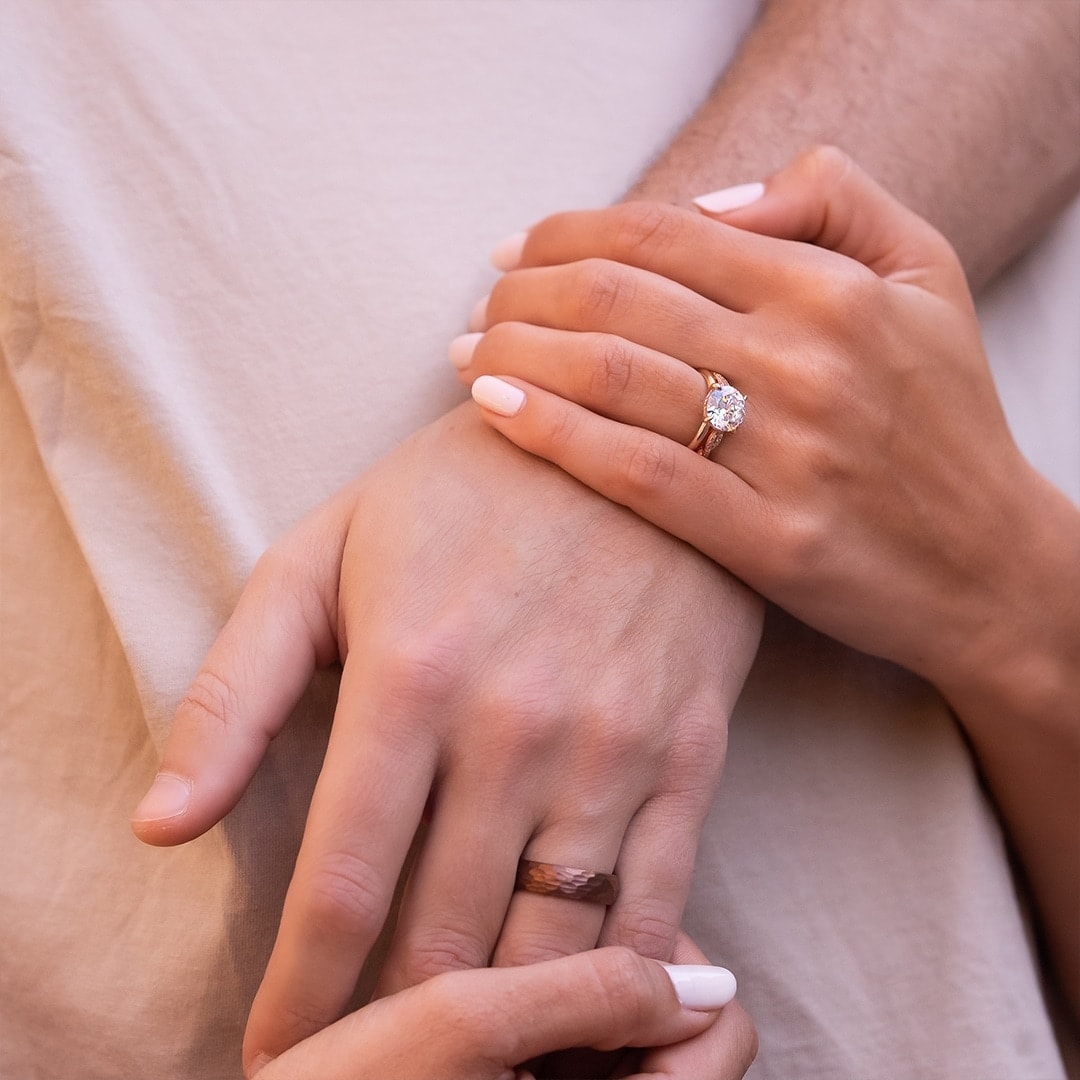 couple holding each other wearing wedding rings
