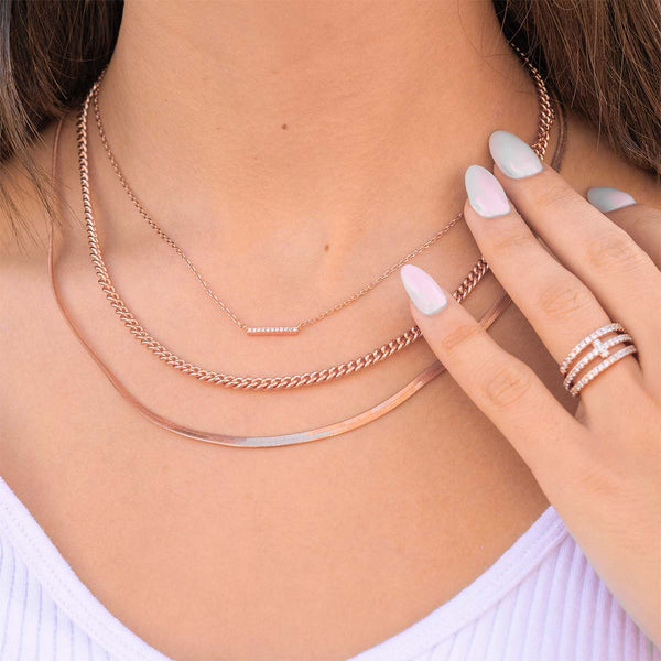 Layered rose gold necklaces on woman