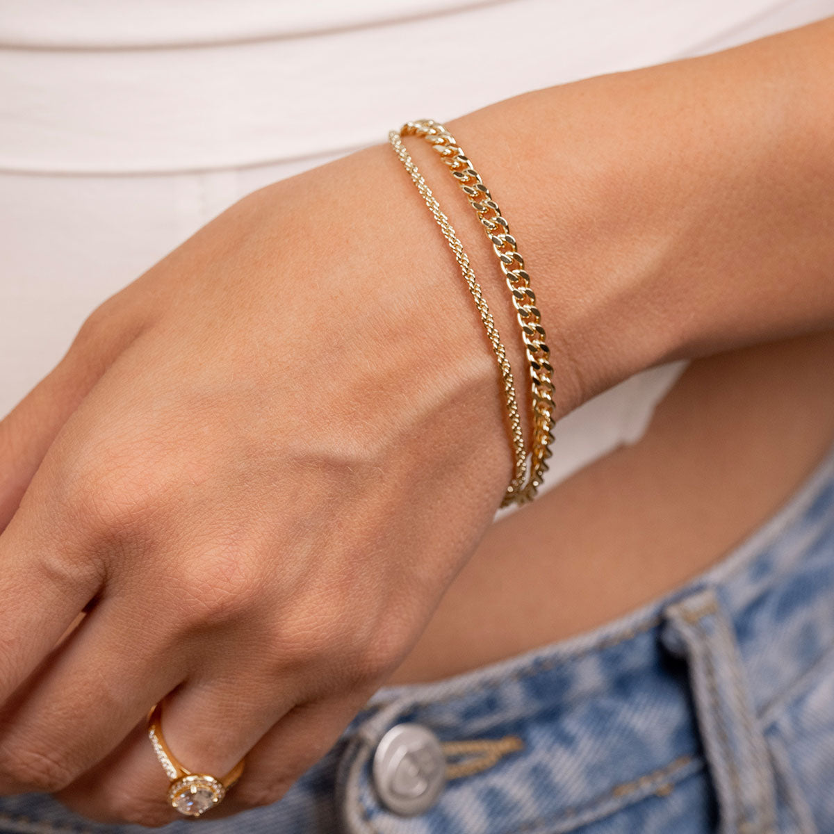 Layered gold rope bracelet on model