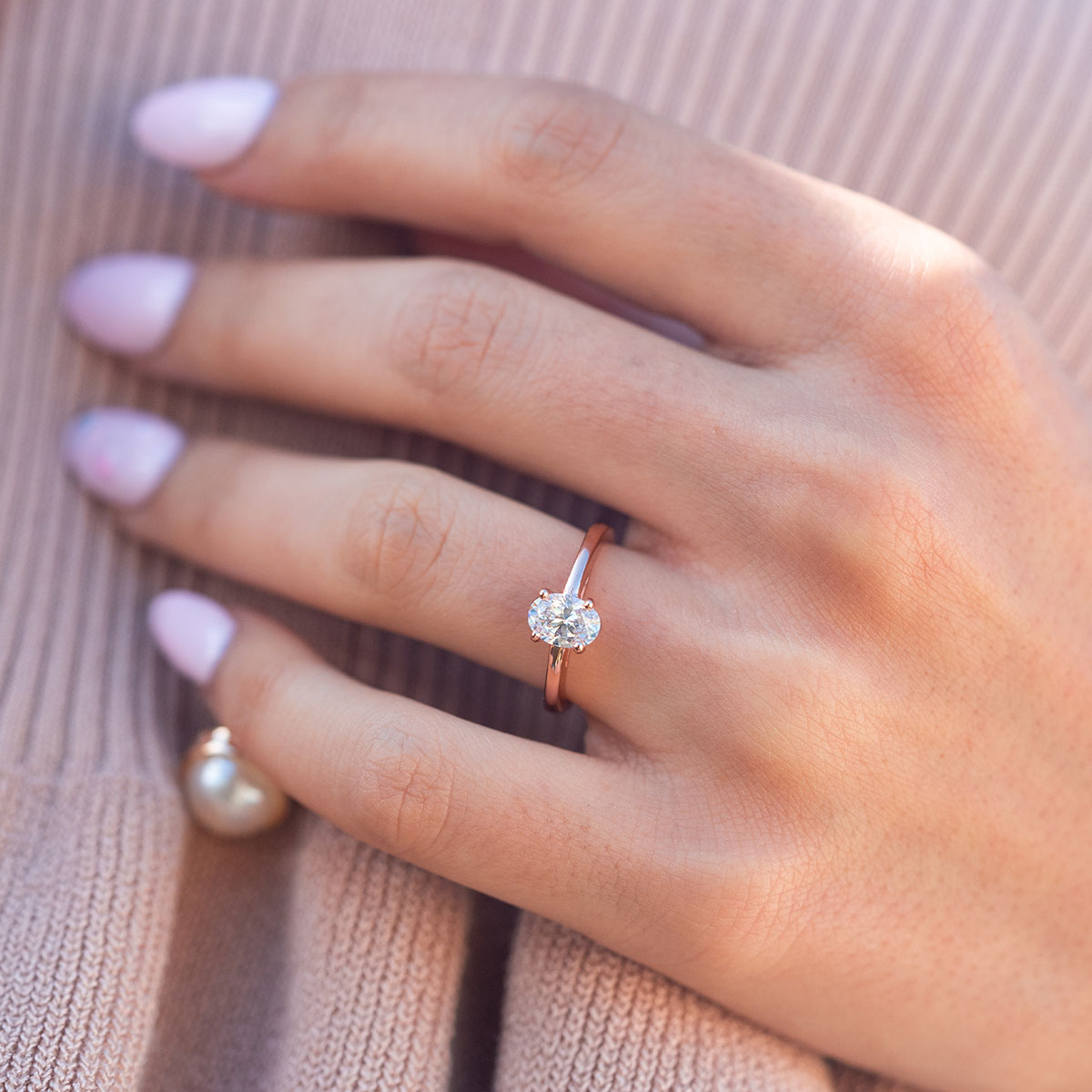 Oval rose gold ring on woman's hand
