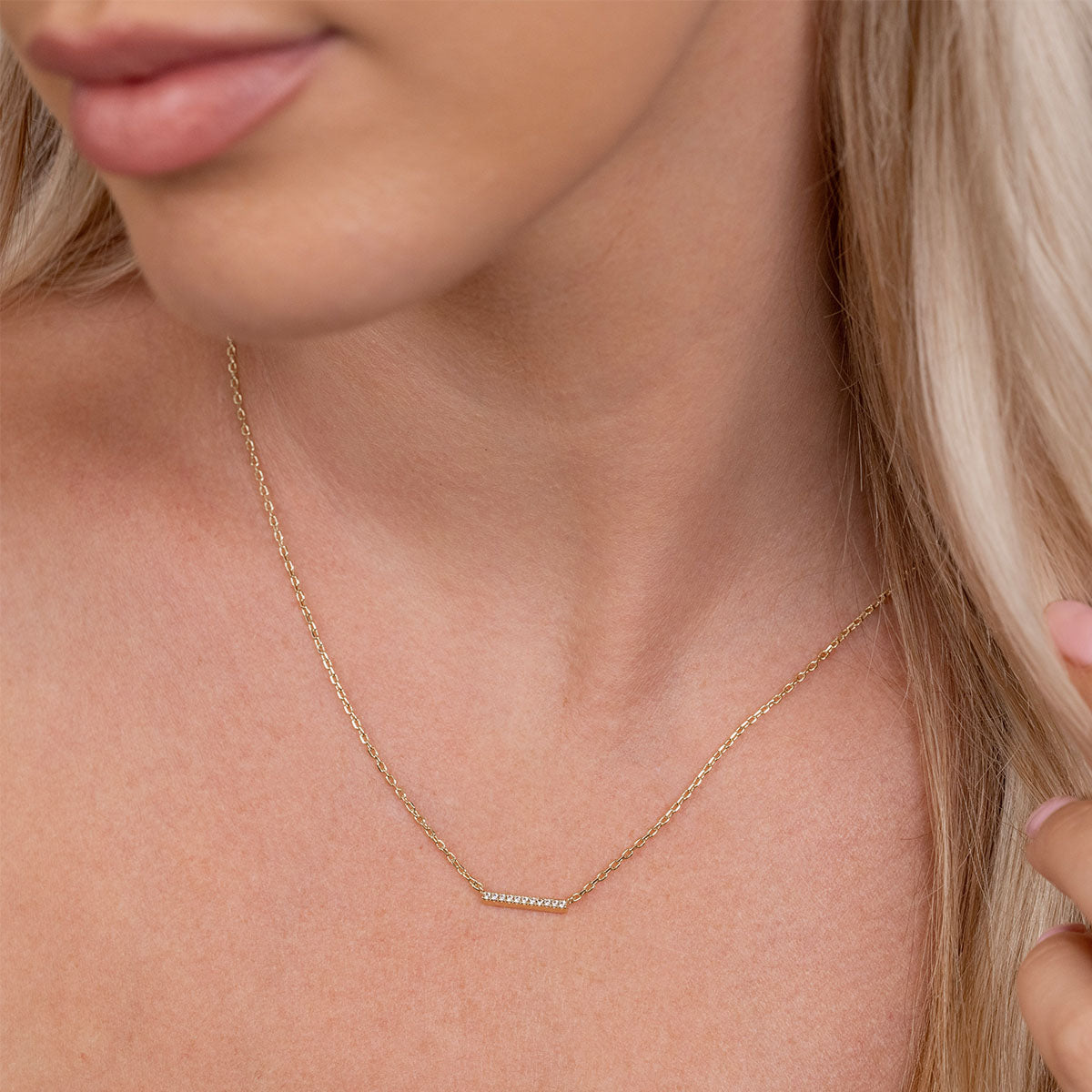 Dainty gold bar necklace on model