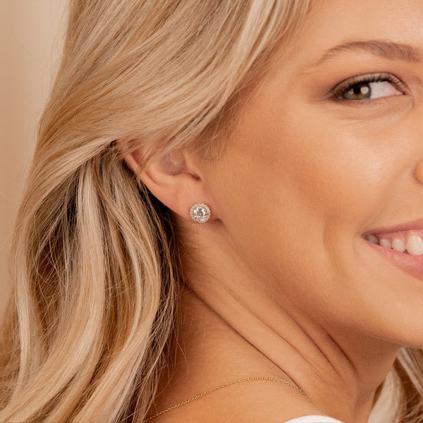 Shimmering gold stud earrings with halo
