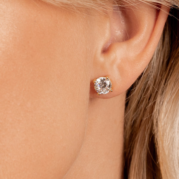 Gold simple stud earrings on model
