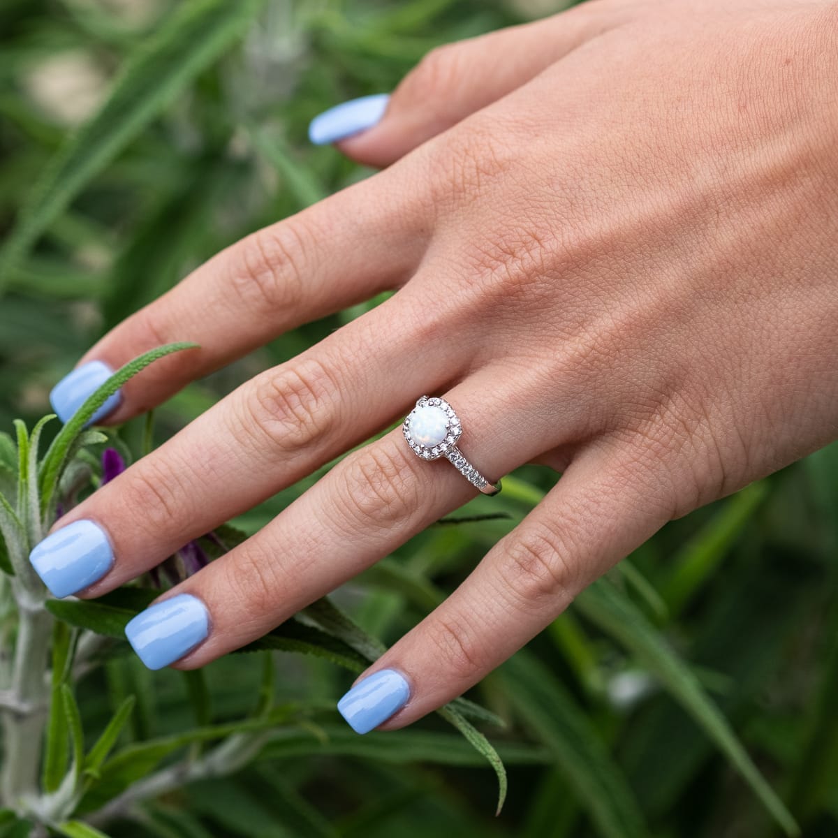 hand with the halo opal engagement ring