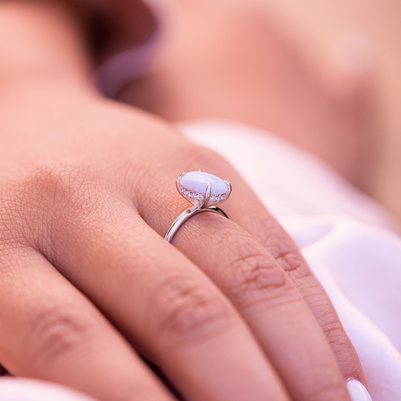 Woman wearing an opal hidden halo engagement ring