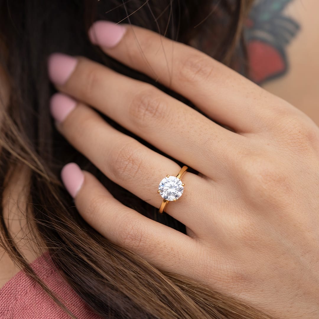 lady wearing the one and only gold round cut solitaire engagement ring