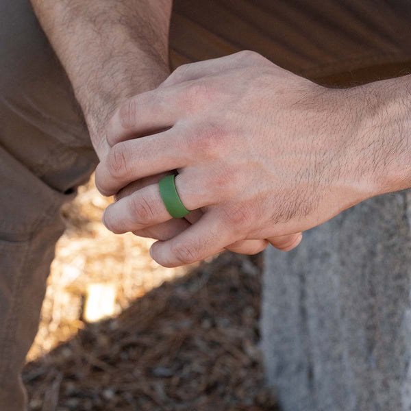 Green rounded rubber ring on a male hand