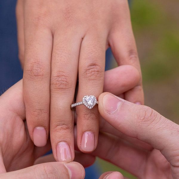 couple putting on sweetheart engagement ring