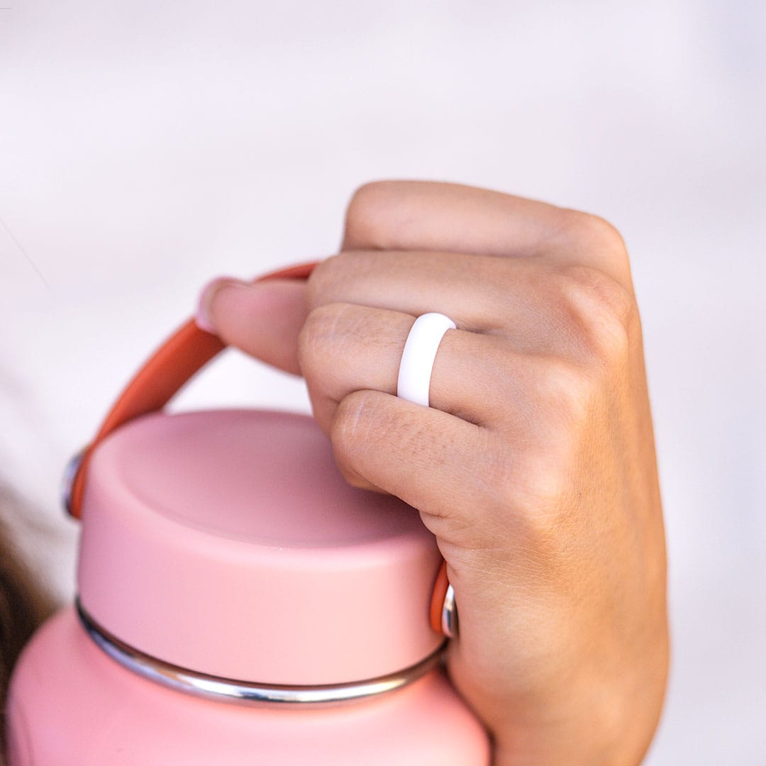 hand holding water bottle wearing white flex silicone ring