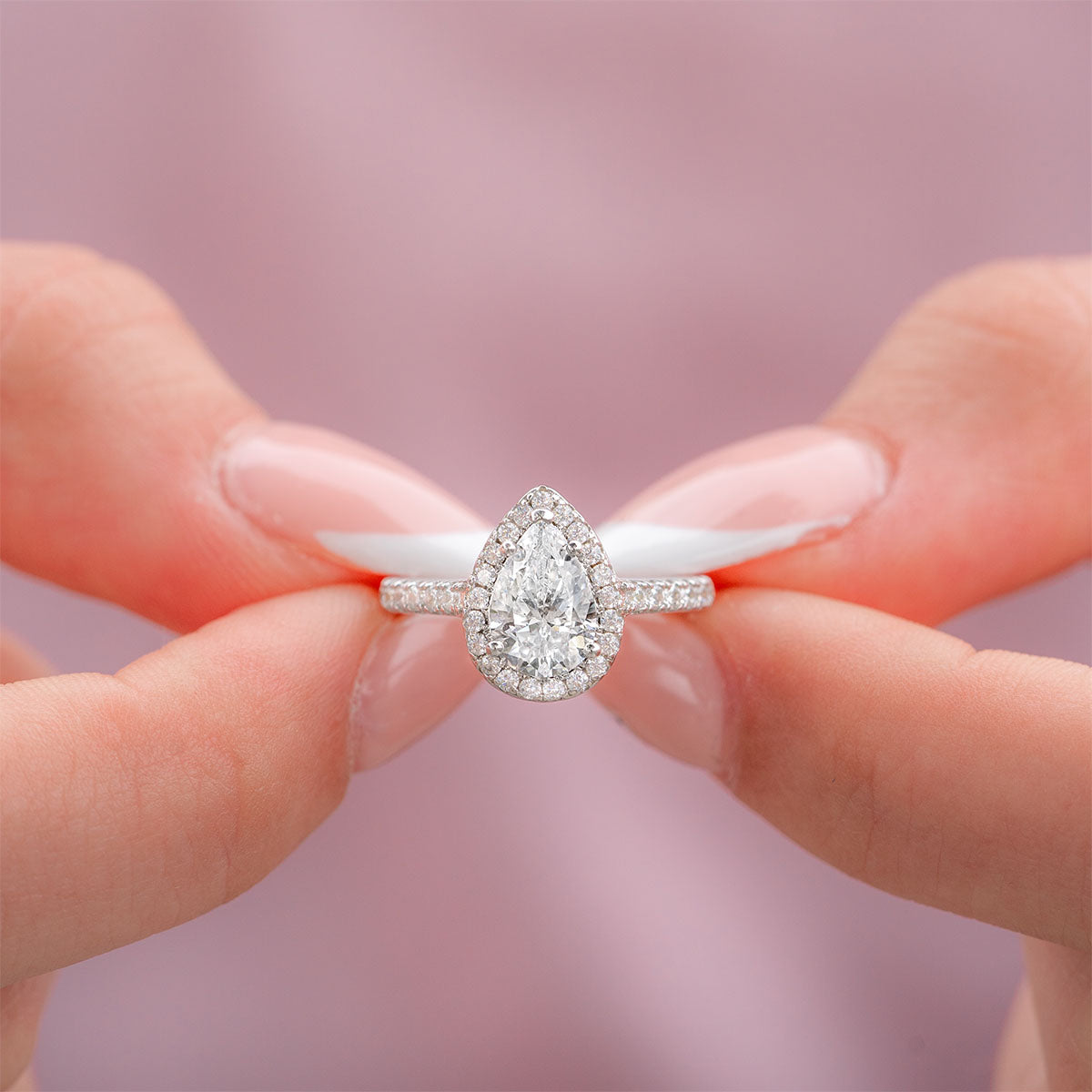 Woman holding silver pear engagement ring