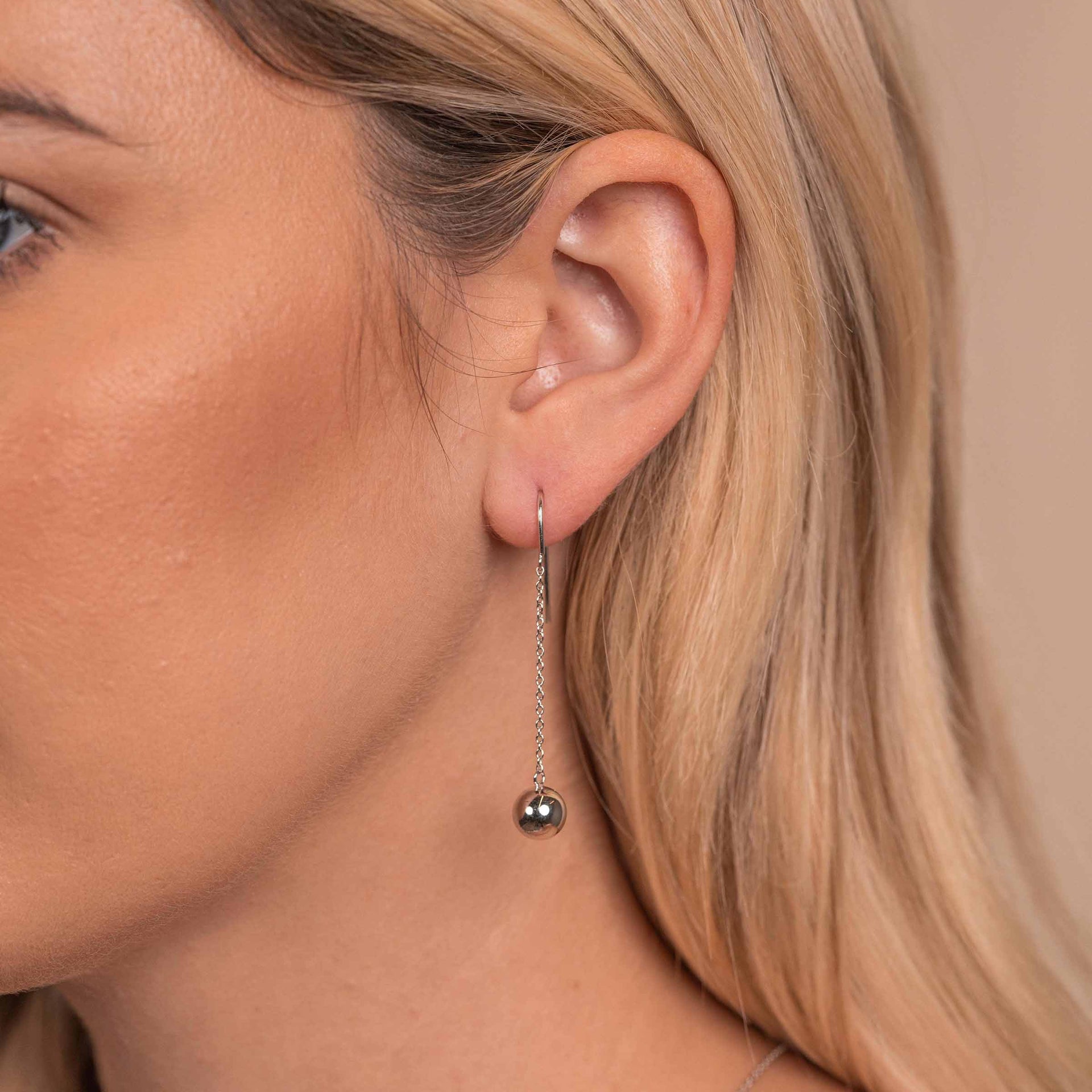 Dangly silver earrings on model